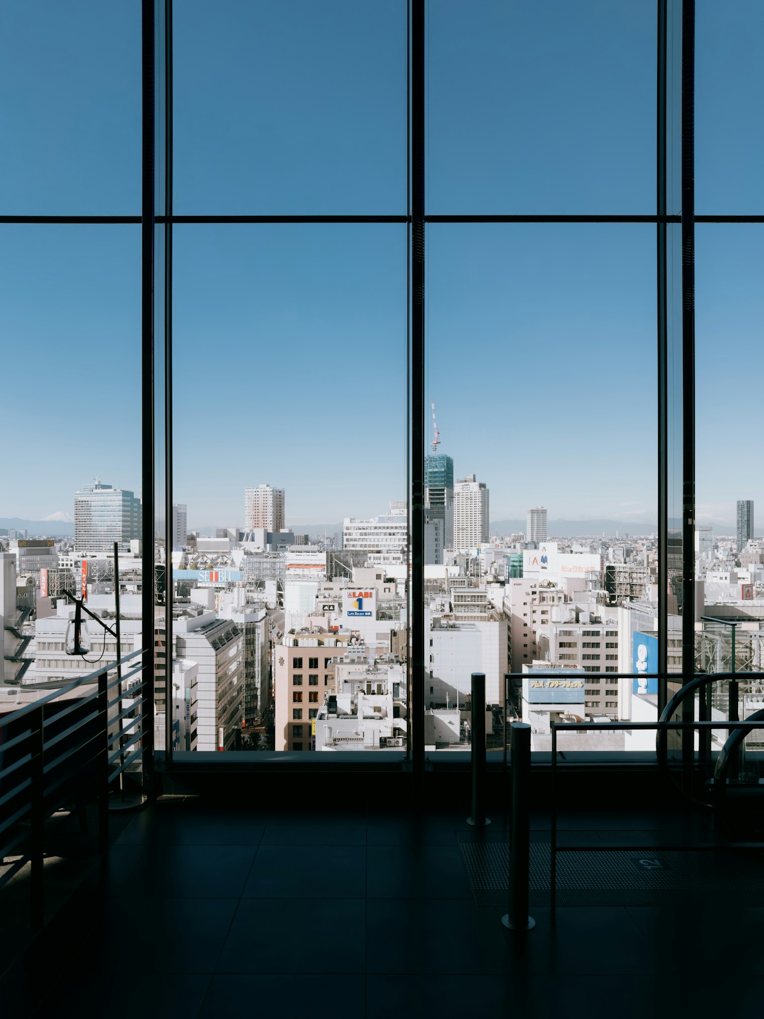 Khung cảnh đường chân trời Tokyo qua cửa sổ lớn bầu trời xanh trong và cảnh quan đô thị