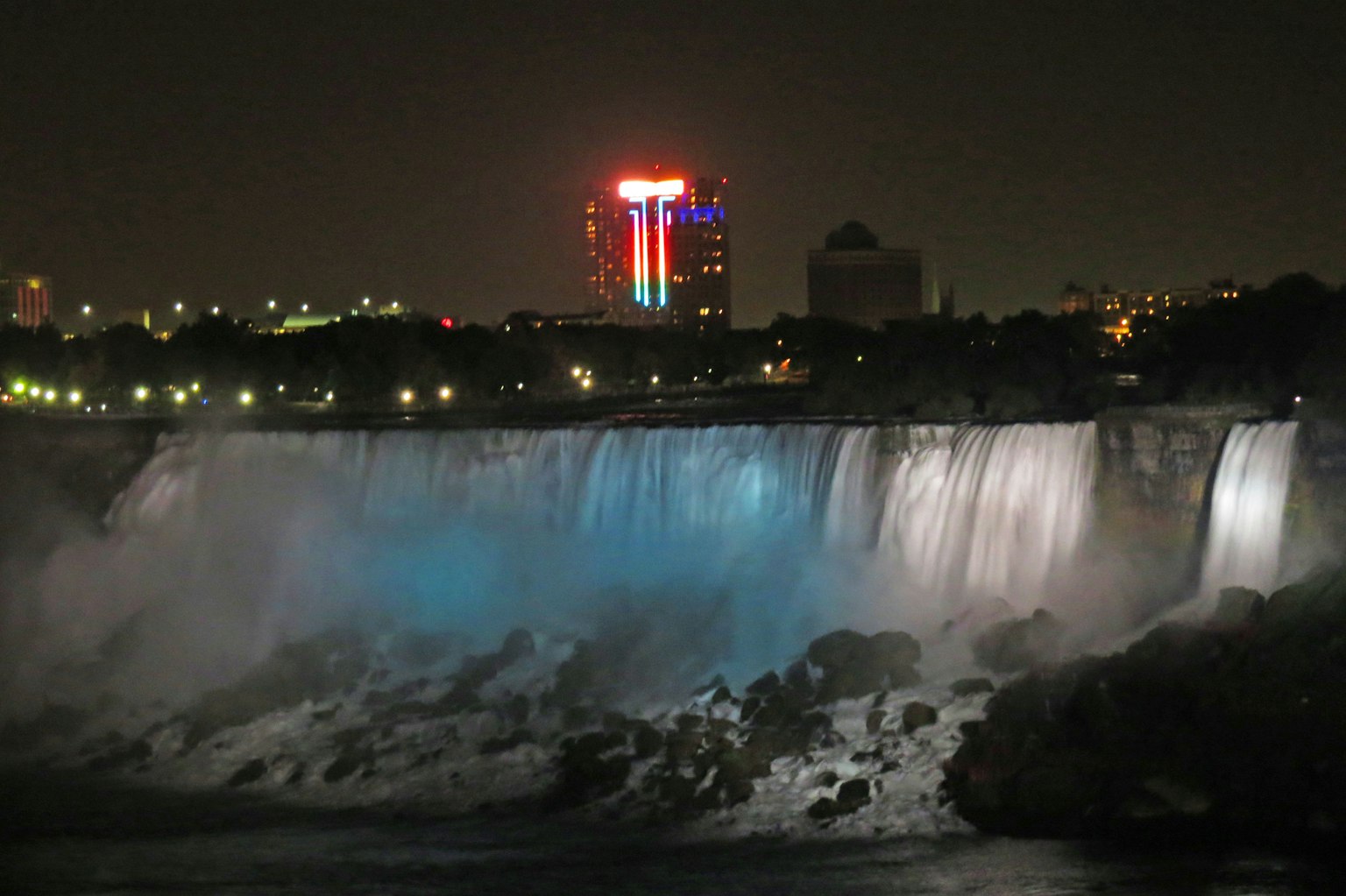Cảnh đêm của thác Niagara được chiếu sáng bằng đèn xanh và các tòa nhà xung quanh