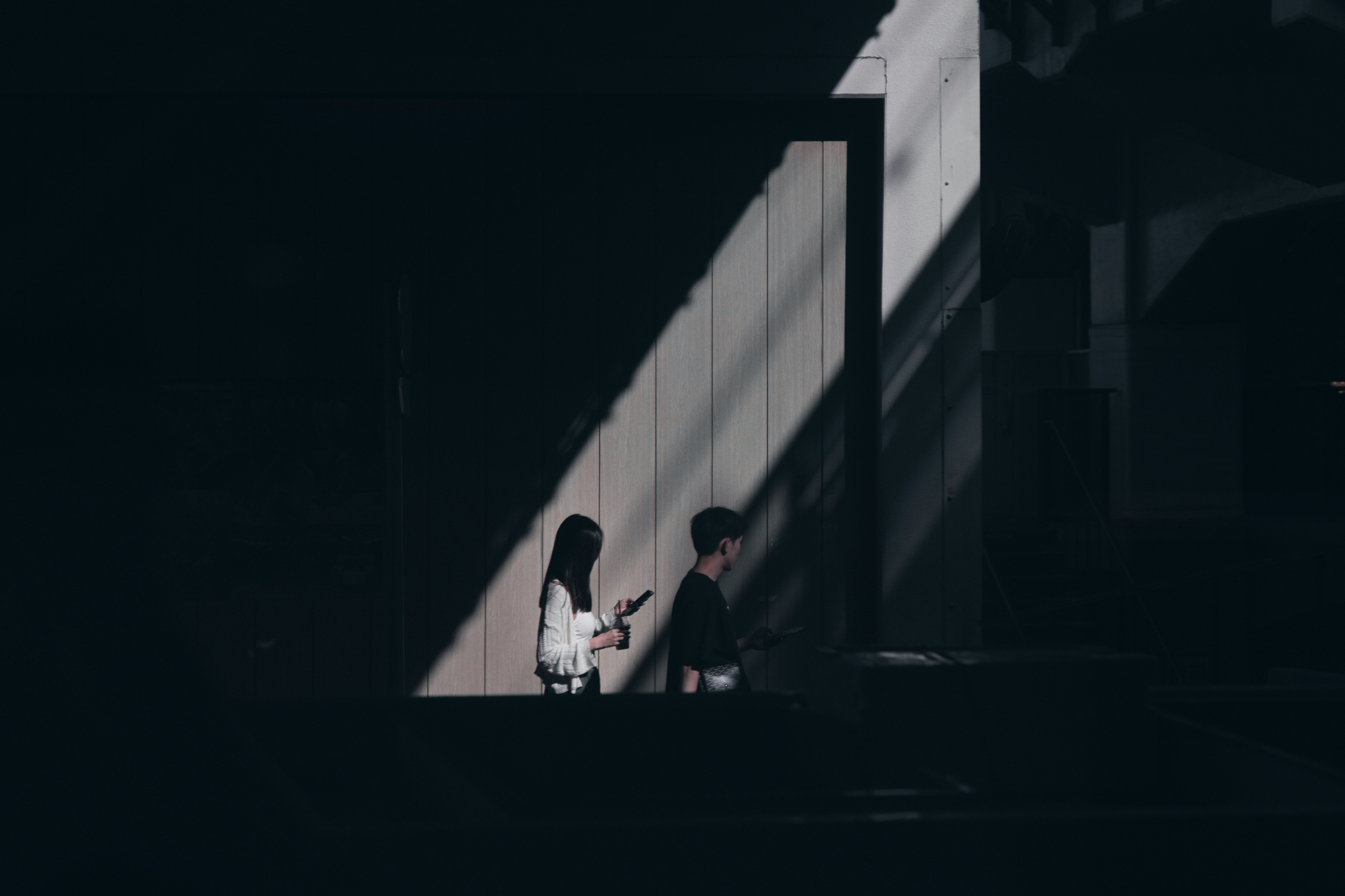 兩人在陰影中的樓梯上交談