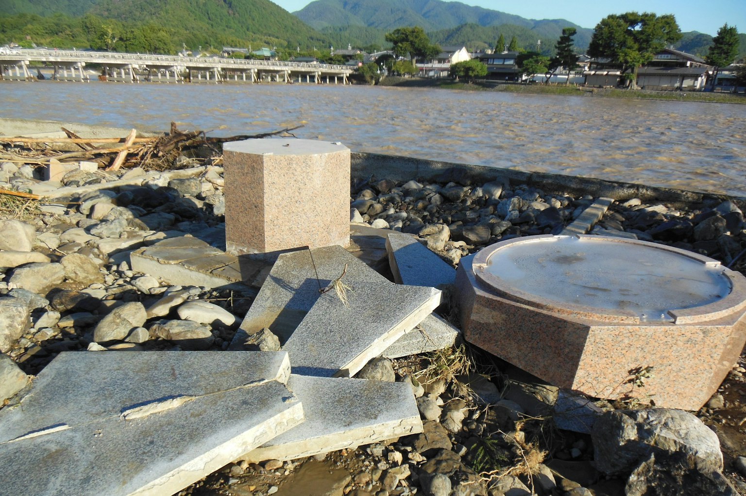Puing batu dan beton yang berserakan di tepi sungai