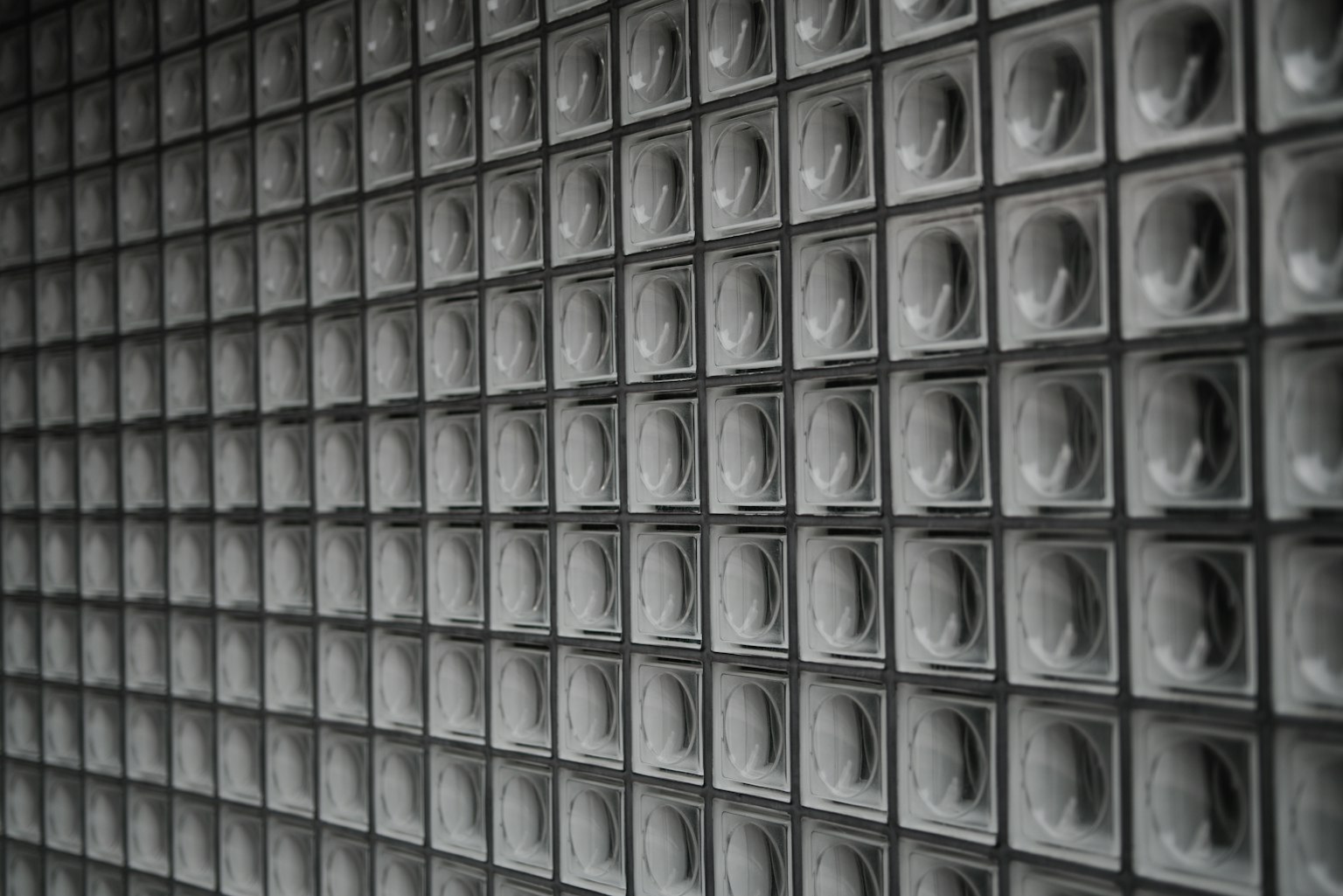 Image features a textured wall with a grid of glass blocks