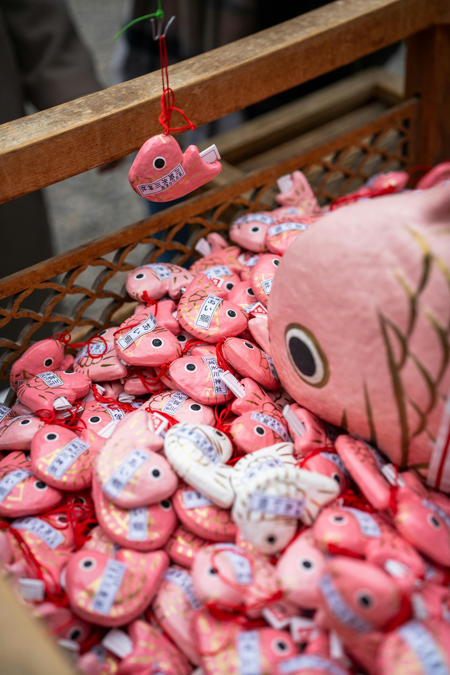 A basket filled with pink fish plush toys and charms