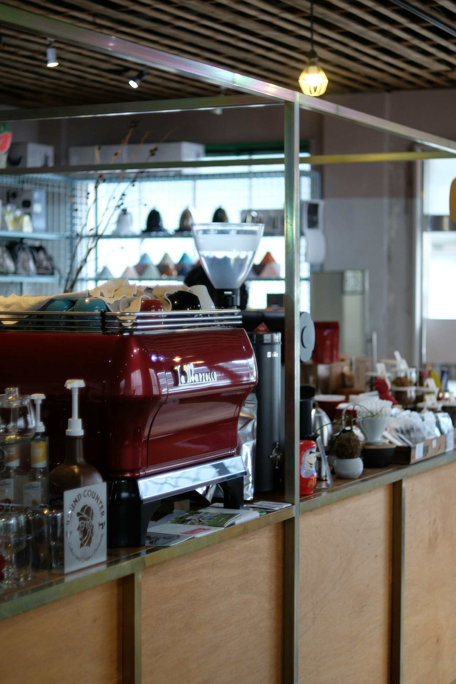 Cafetheke mit einer roten Espressomaschine und verschiedenen Kaffeebedarf