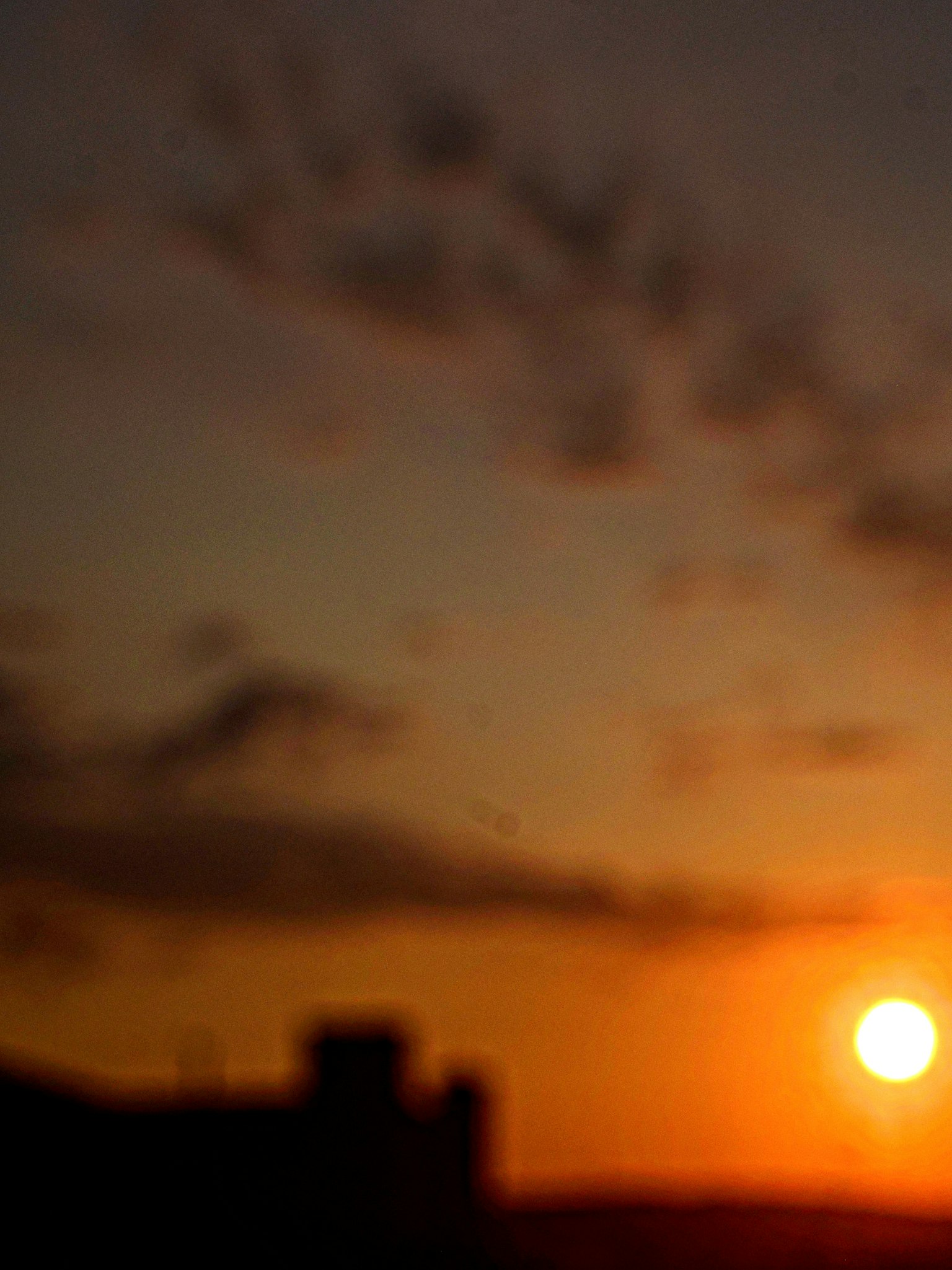 Senja kabur dengan siluet awan dan bangunan