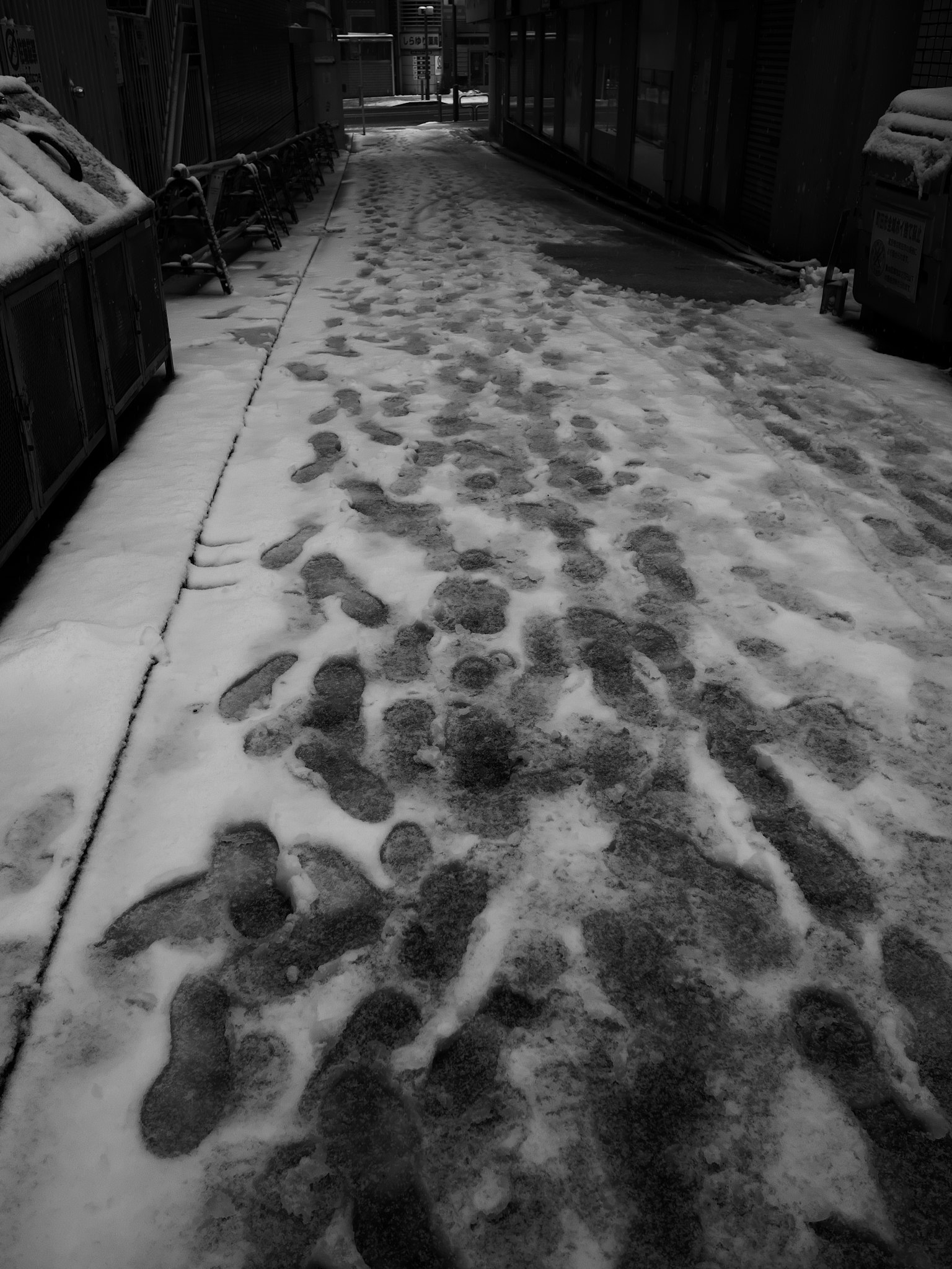 一条狭窄的小巷，雪中留下的足迹