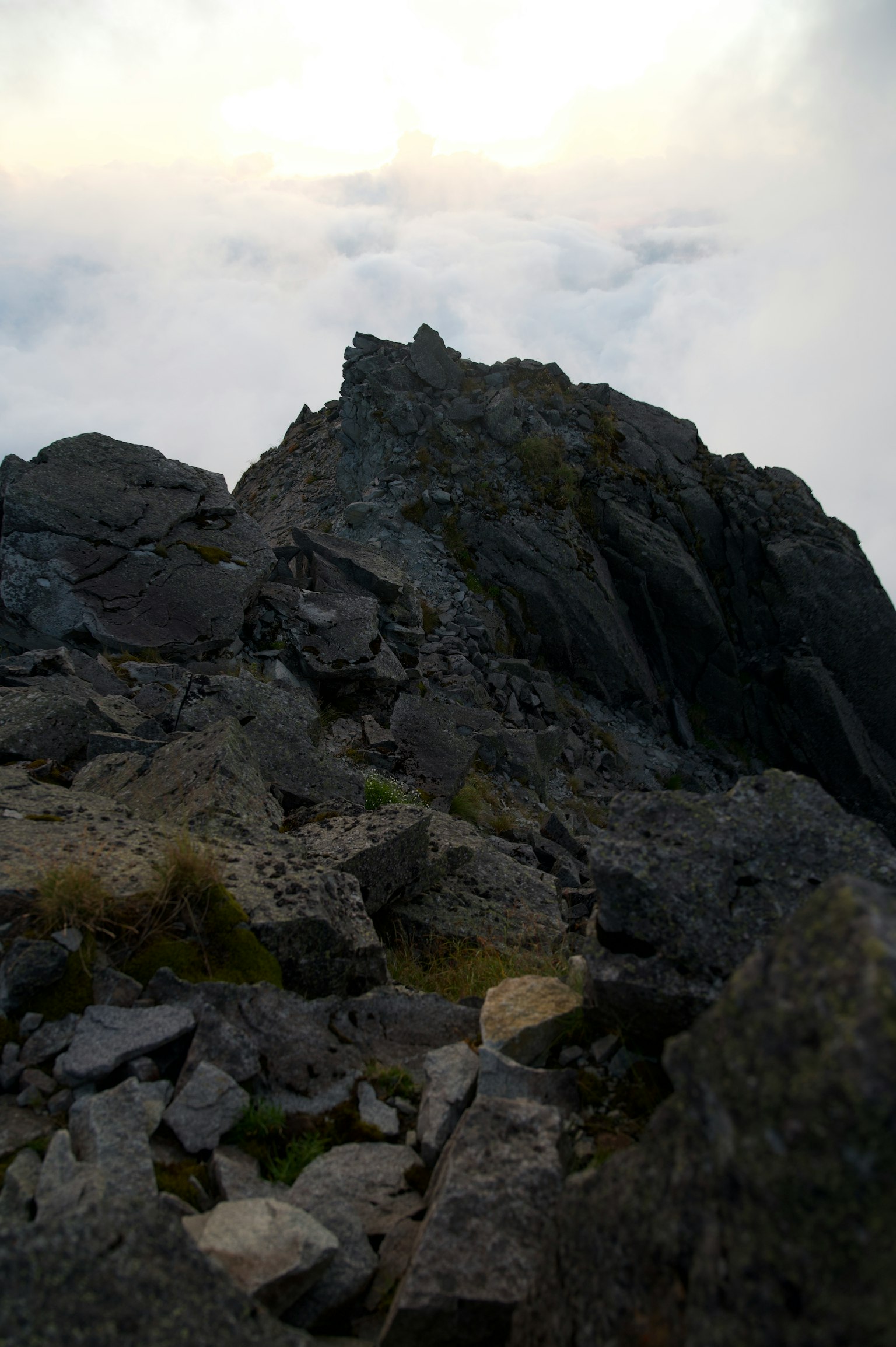 Vue d'un sommet montagneux escarpé avec un terrain rocheux et des nuages en arrière-plan