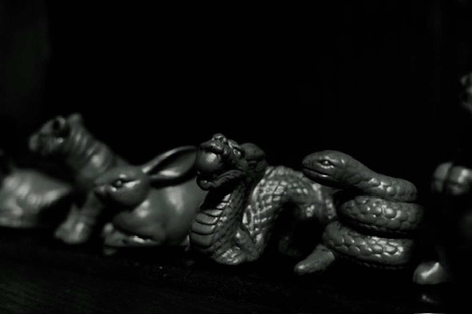 Sculptures d'animaux alignées sur fond noir