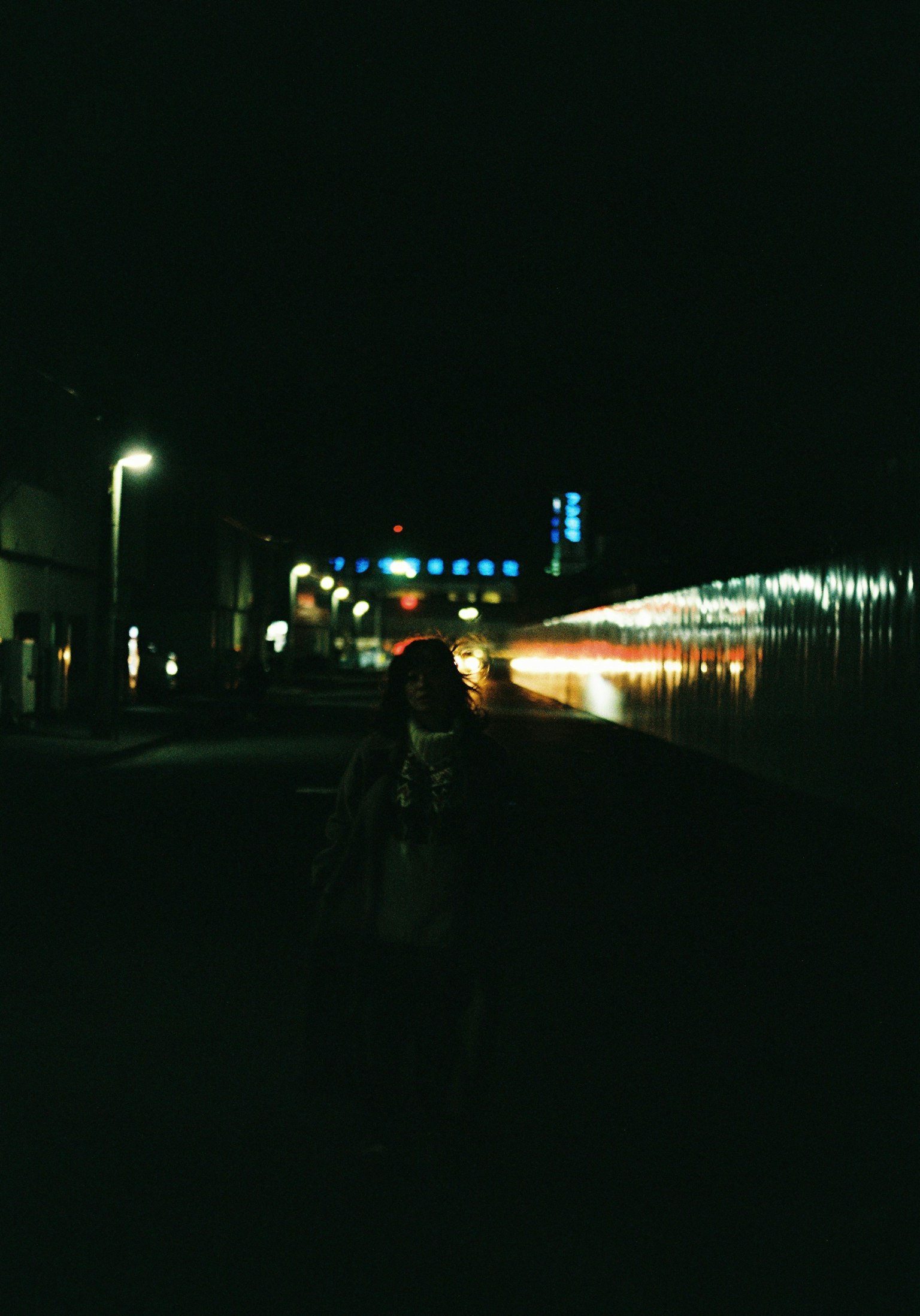 ฉากตอนกลางคืนของสถานีรถไฟพร้อมแสงสว่างและเงาของคน