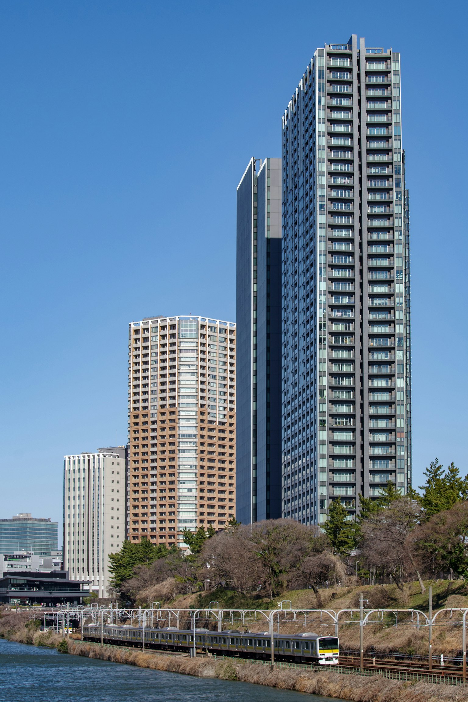 Horizon urbain avec des bâtiments hauts et un ciel bleu clair près d'une voie ferrée