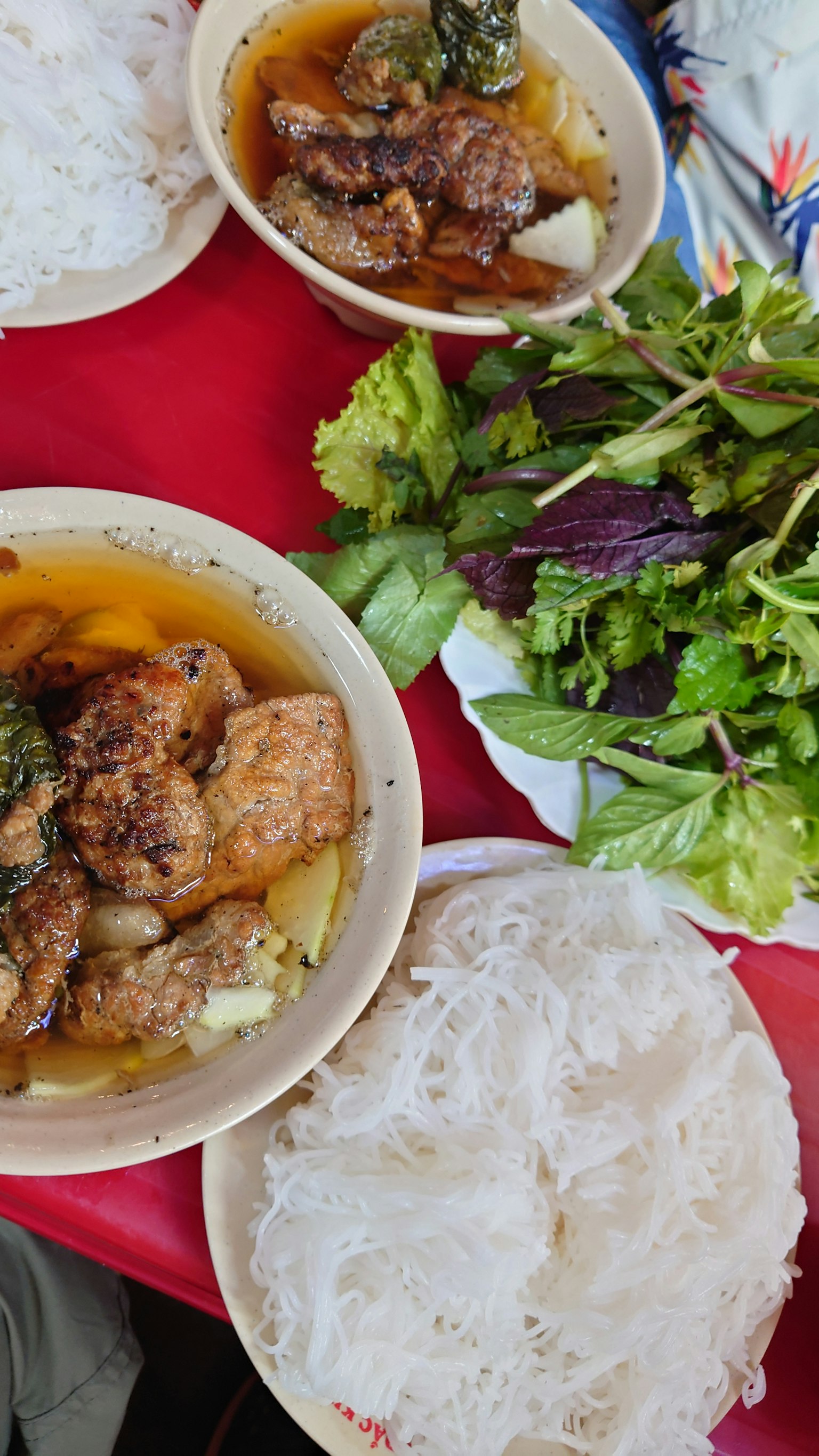 Piring nasi, sayuran, dan hidangan daging yang disusun di atas meja