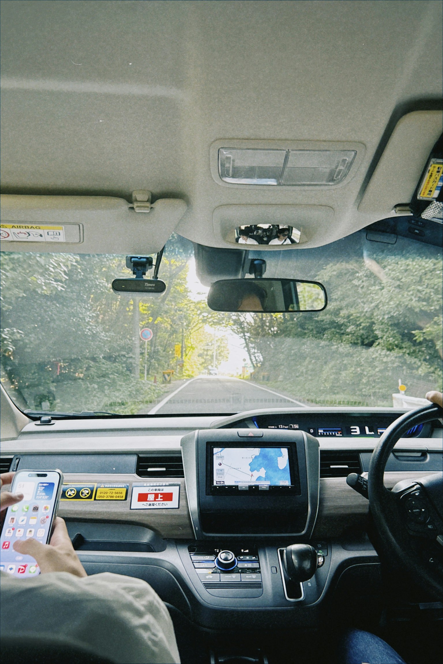 汽車內部視角，顯示儀表板和前方道路及導航顯示