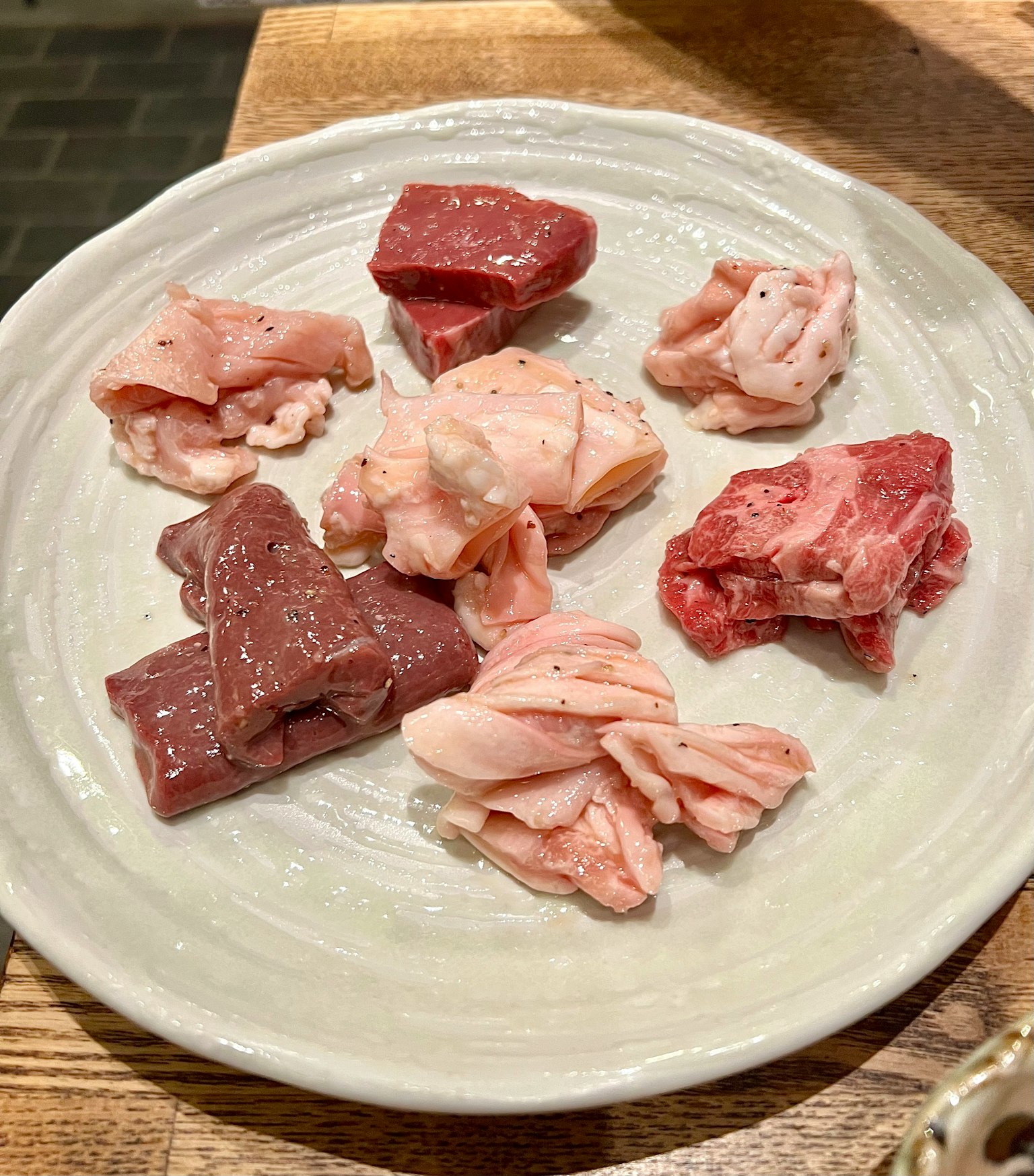 Tagli assortiti di carne disposti su un piatto bianco