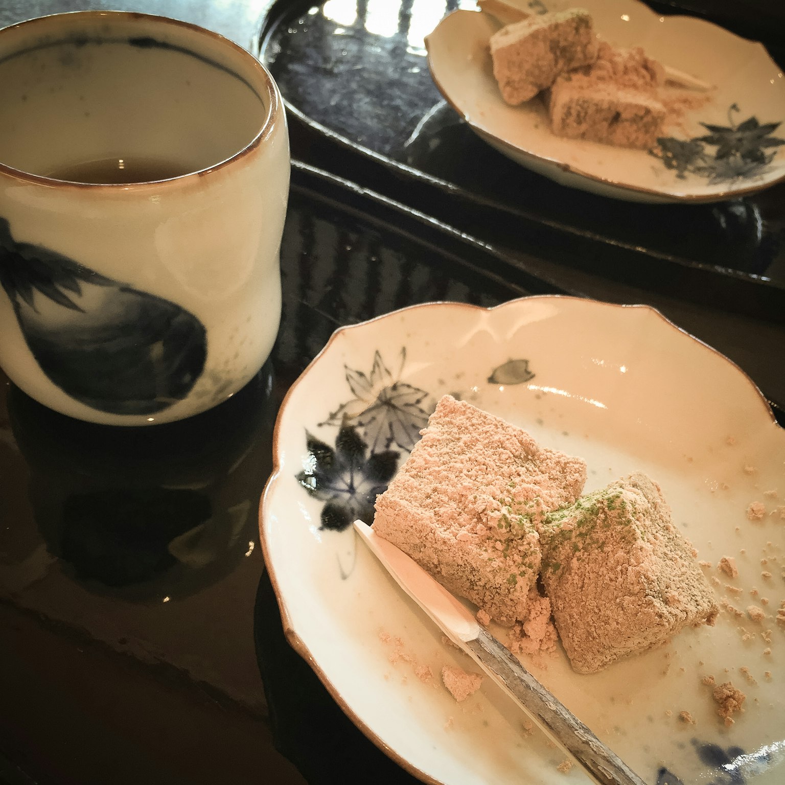 Une tasse de thé et un morceau de confiserie japonaise sur une assiette
