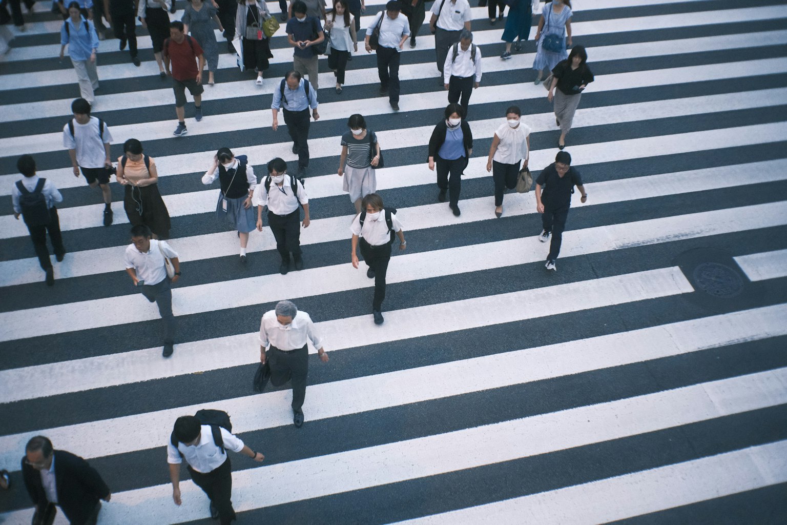 Aerial view of people crossing a pedestrian crosswalk