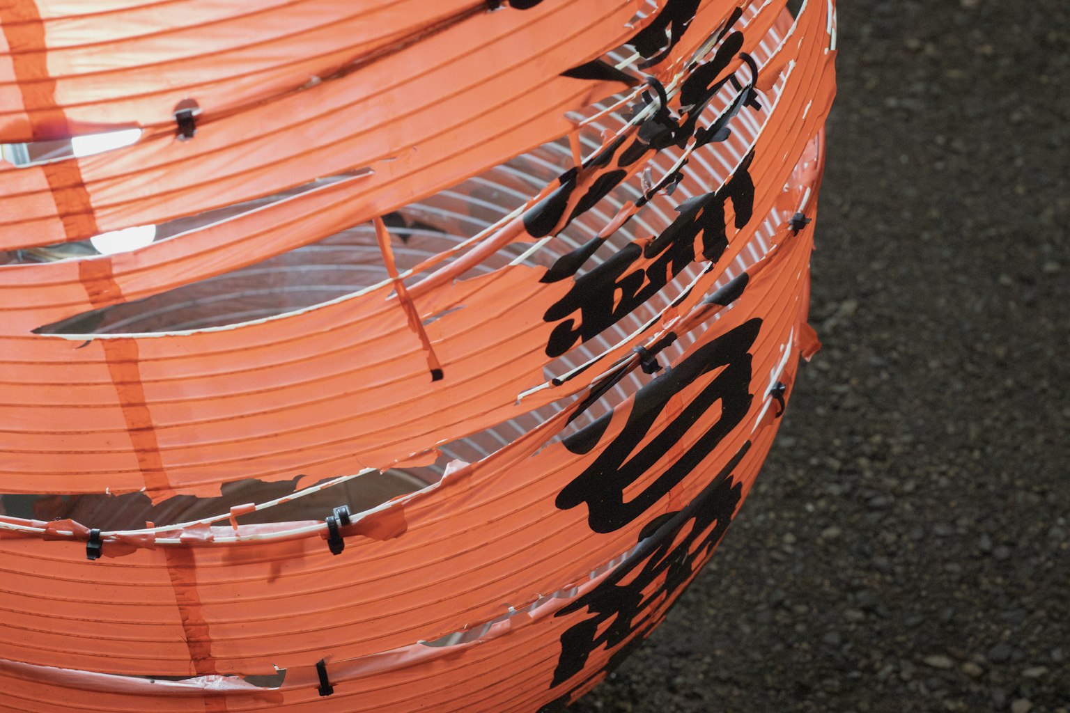 Gros plan d'une lanterne orange avec des caractères japonais noirs
