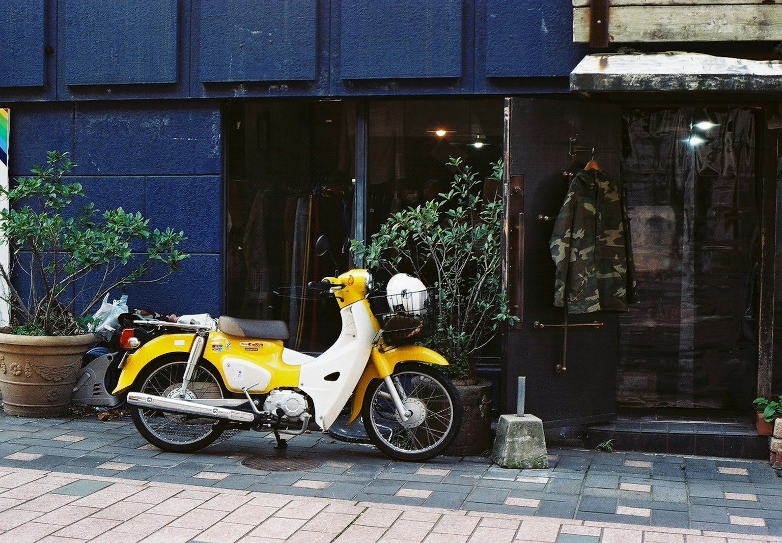 Ein gelbes Scooter vor einem Laden geparkt