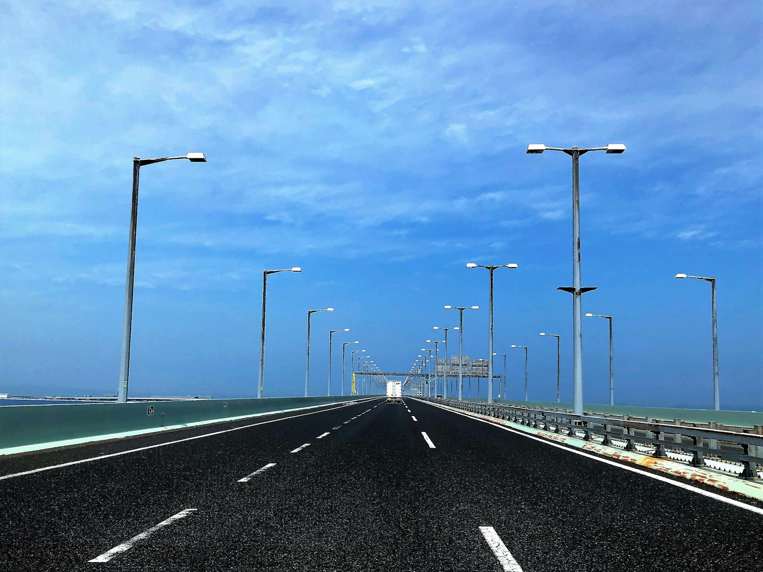 Amplia carretera con farolas bajo un cielo azul
