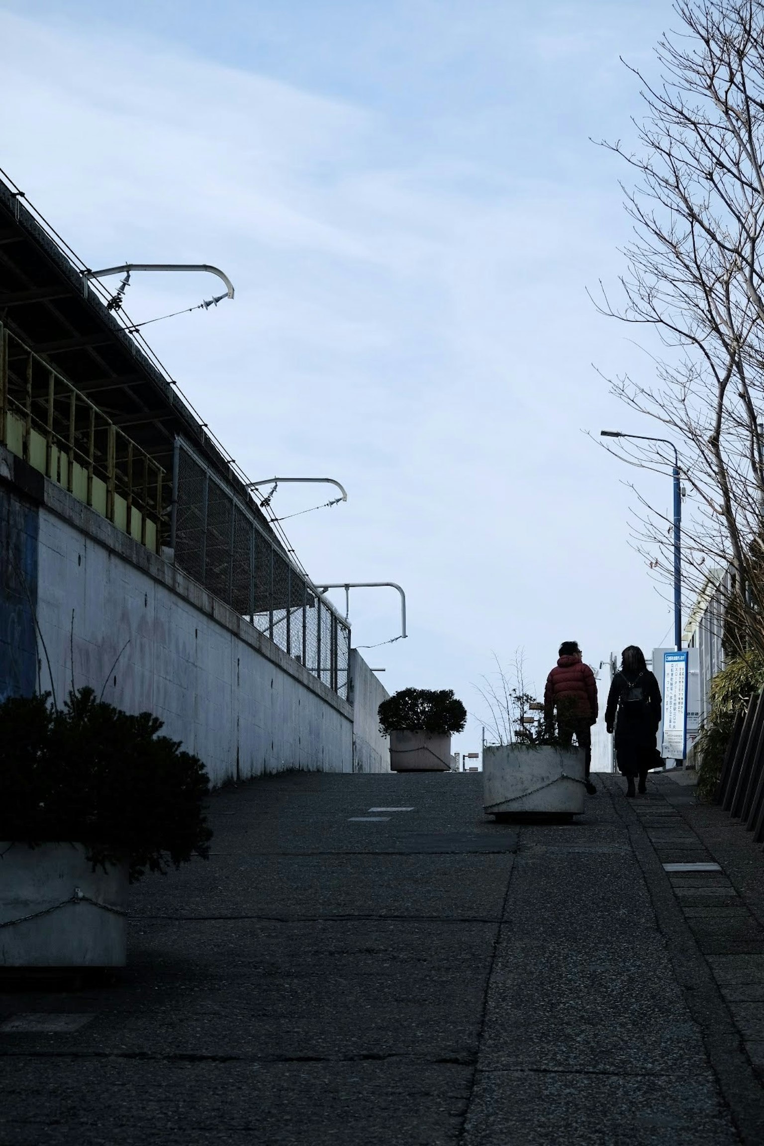 人们在坡道上行走 背景是蓝天和建筑物
