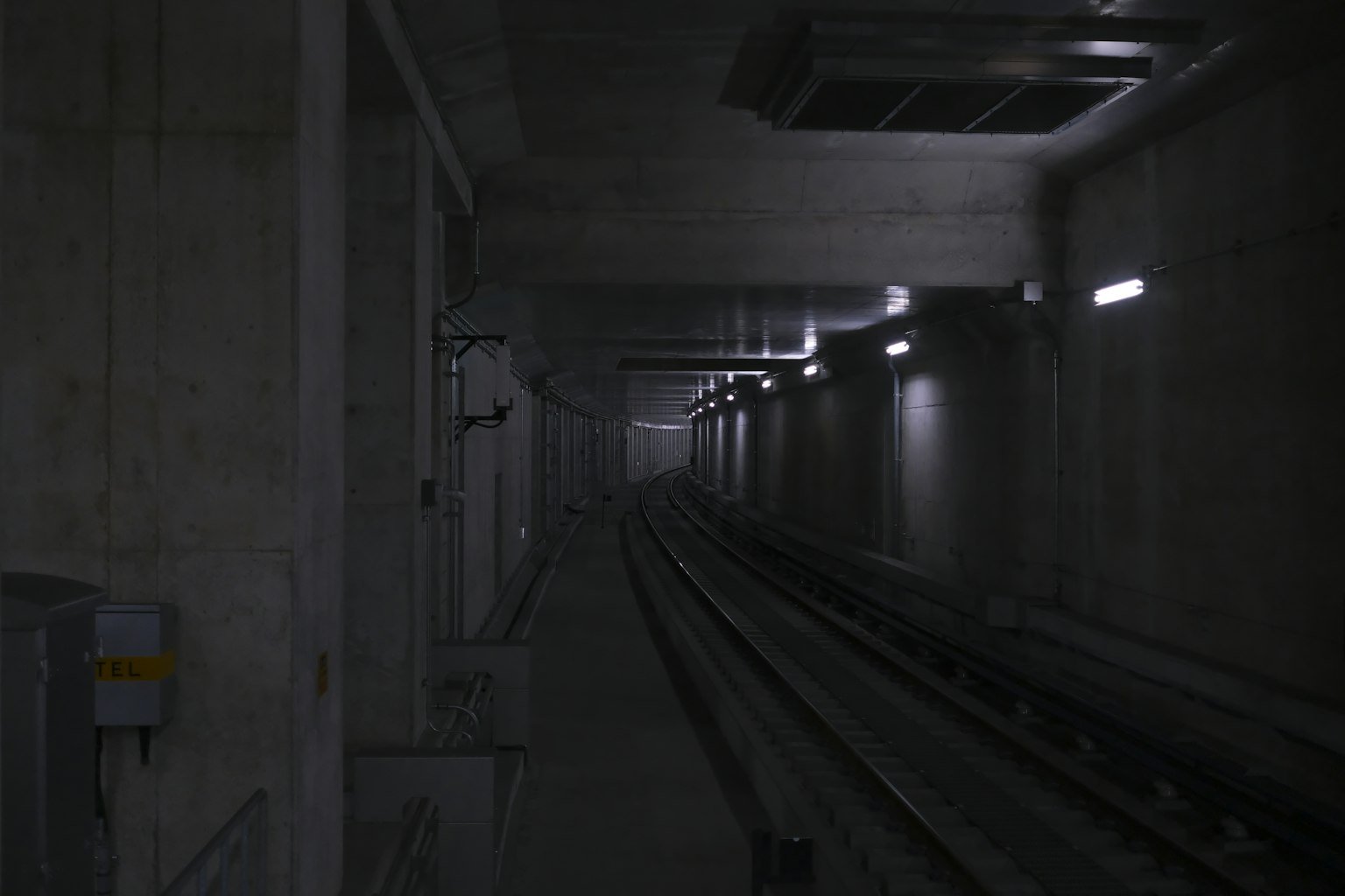 昏暗的地下隧道，帶有鐵路軌道和混凝土牆