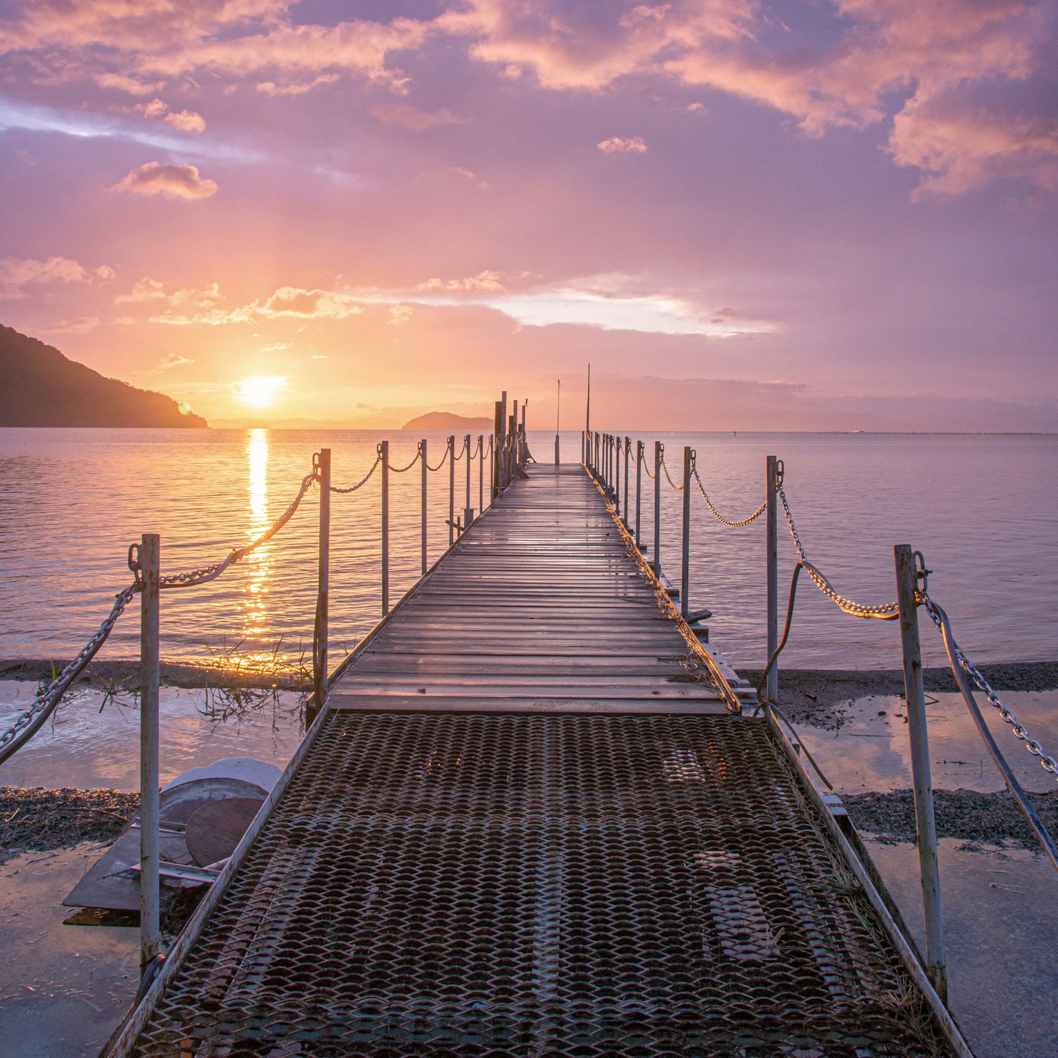 Scenic view of a pier extending into the sea at sunset