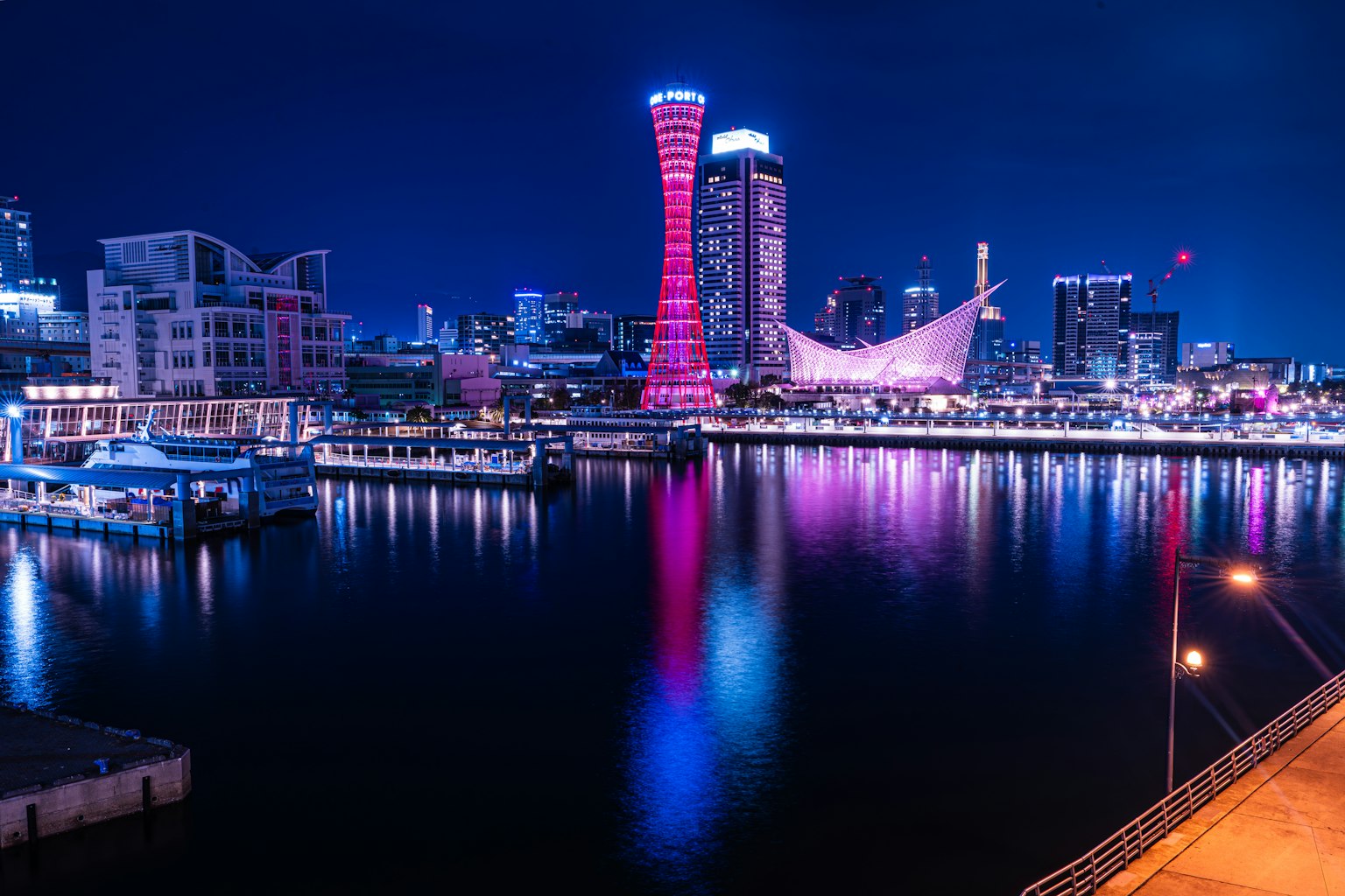 Cảnh đêm đẹp của thành phố cảng Kobe với các tòa nhà chọc trời được chiếu sáng phản chiếu trên mặt nước