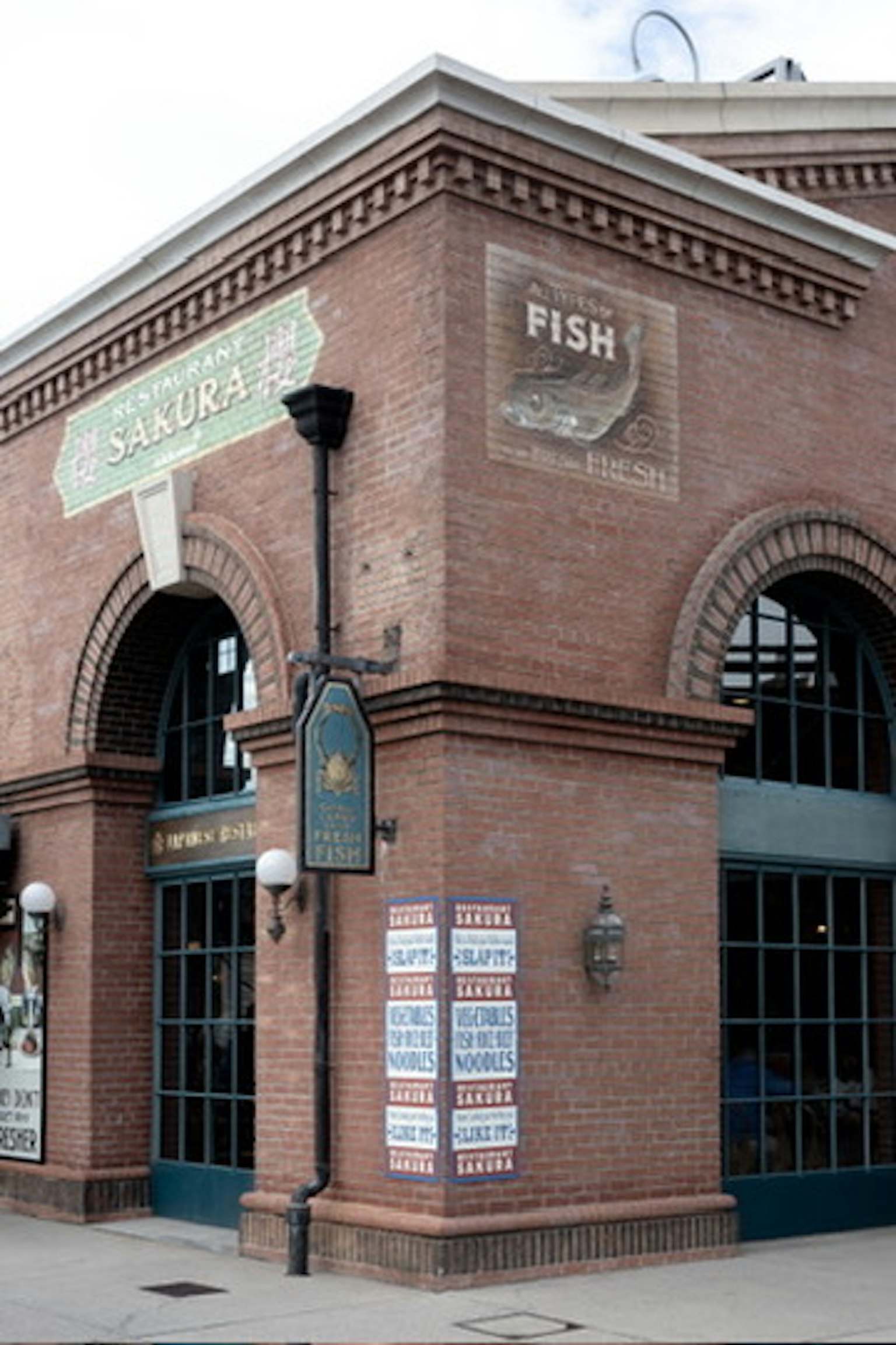 Exterior view of a brick building with a sign reading Sakura