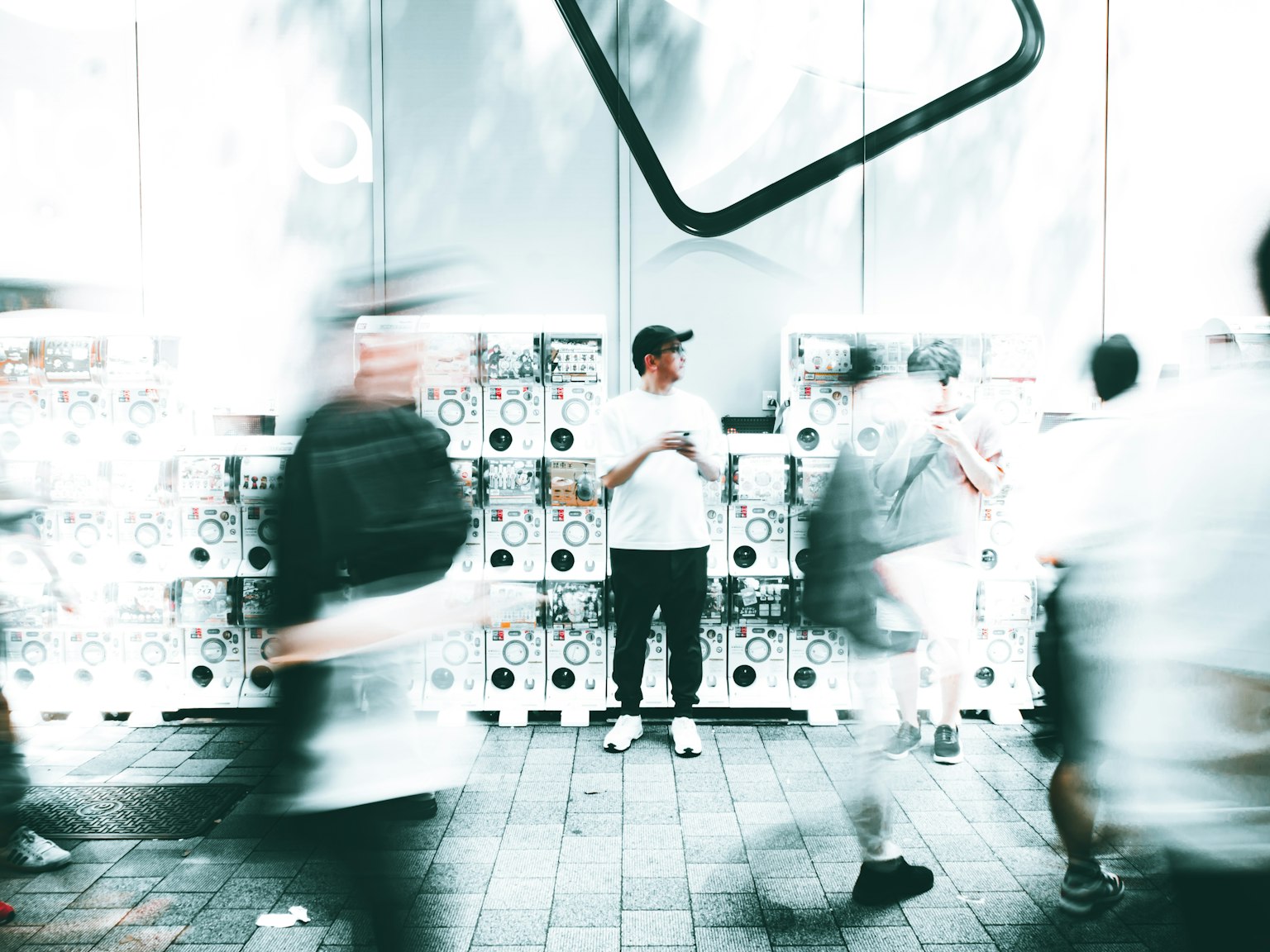 Un uomo in piedi tra il movimento sfocato di persone in un ambiente urbano affollato