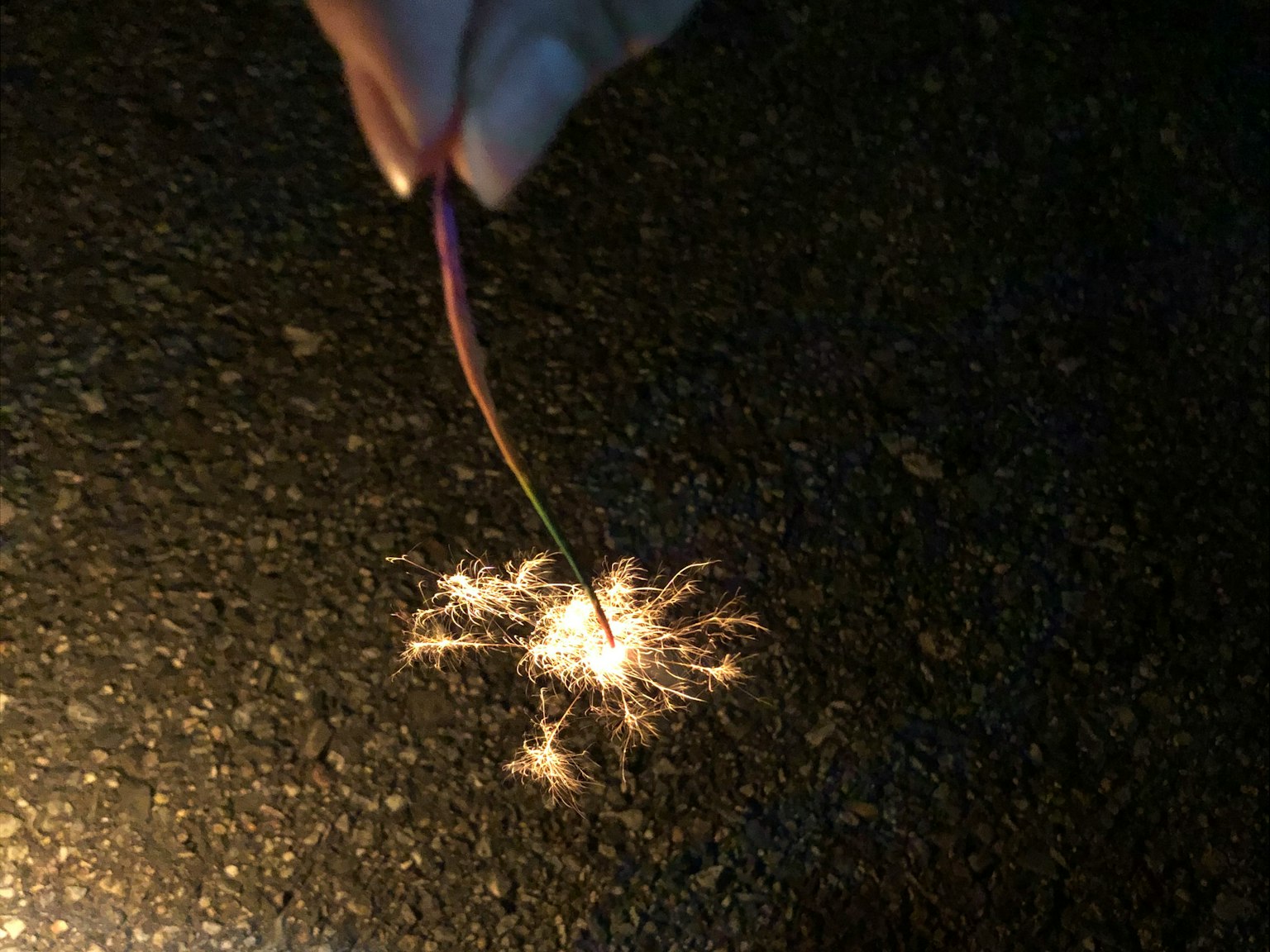A hand creating sparks in a dark setting