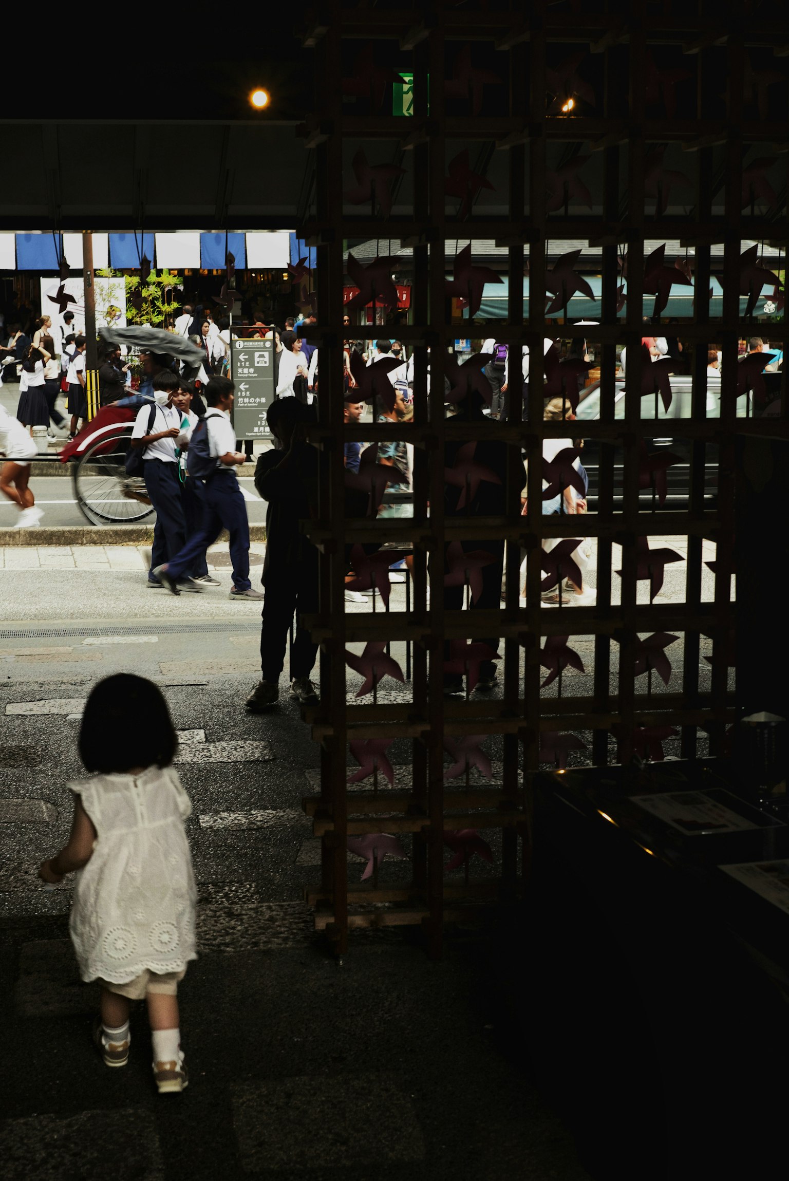 Un niño con un vestido blanco caminando hacia la calle