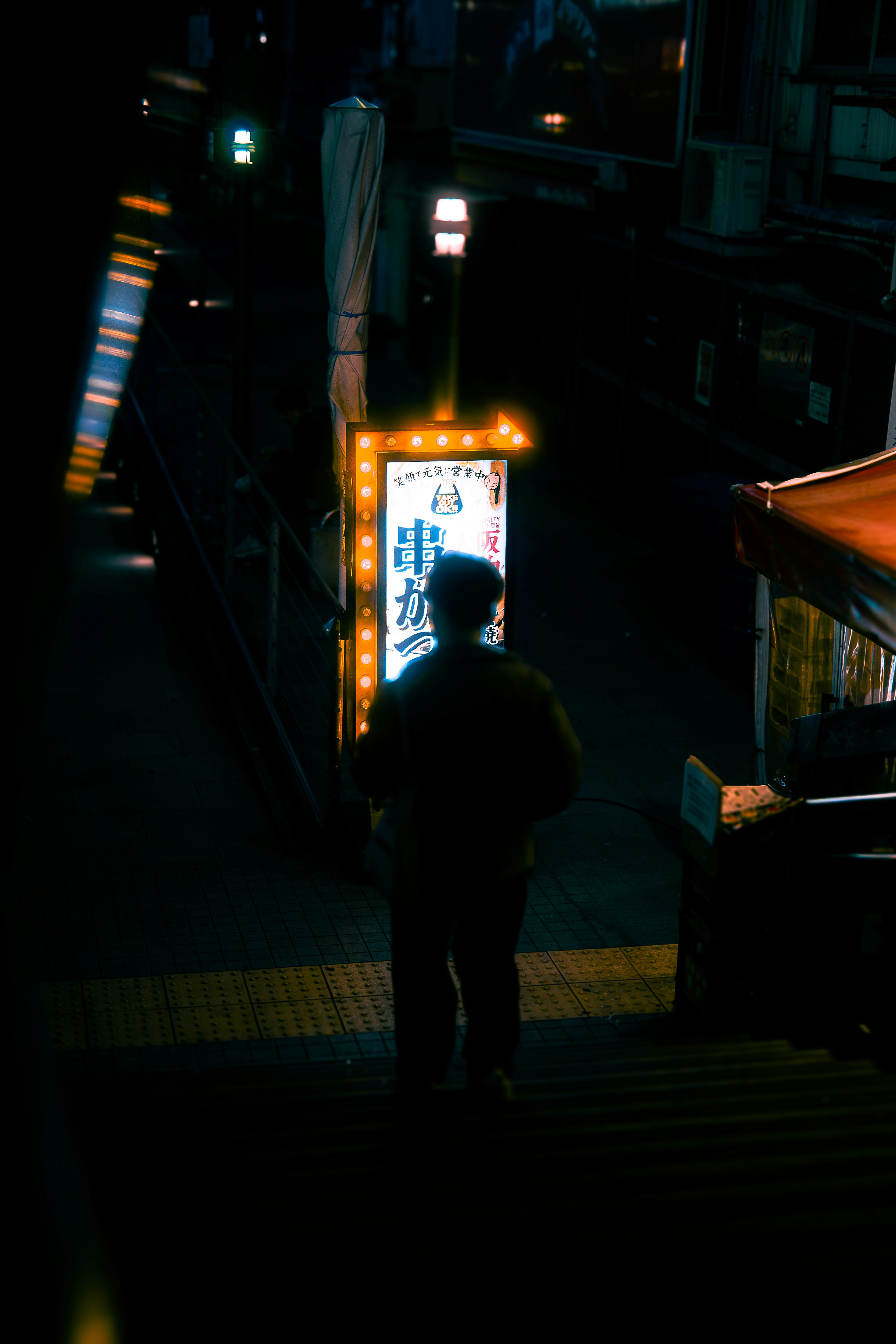 夜晚小巷里发光招牌与人影的街景