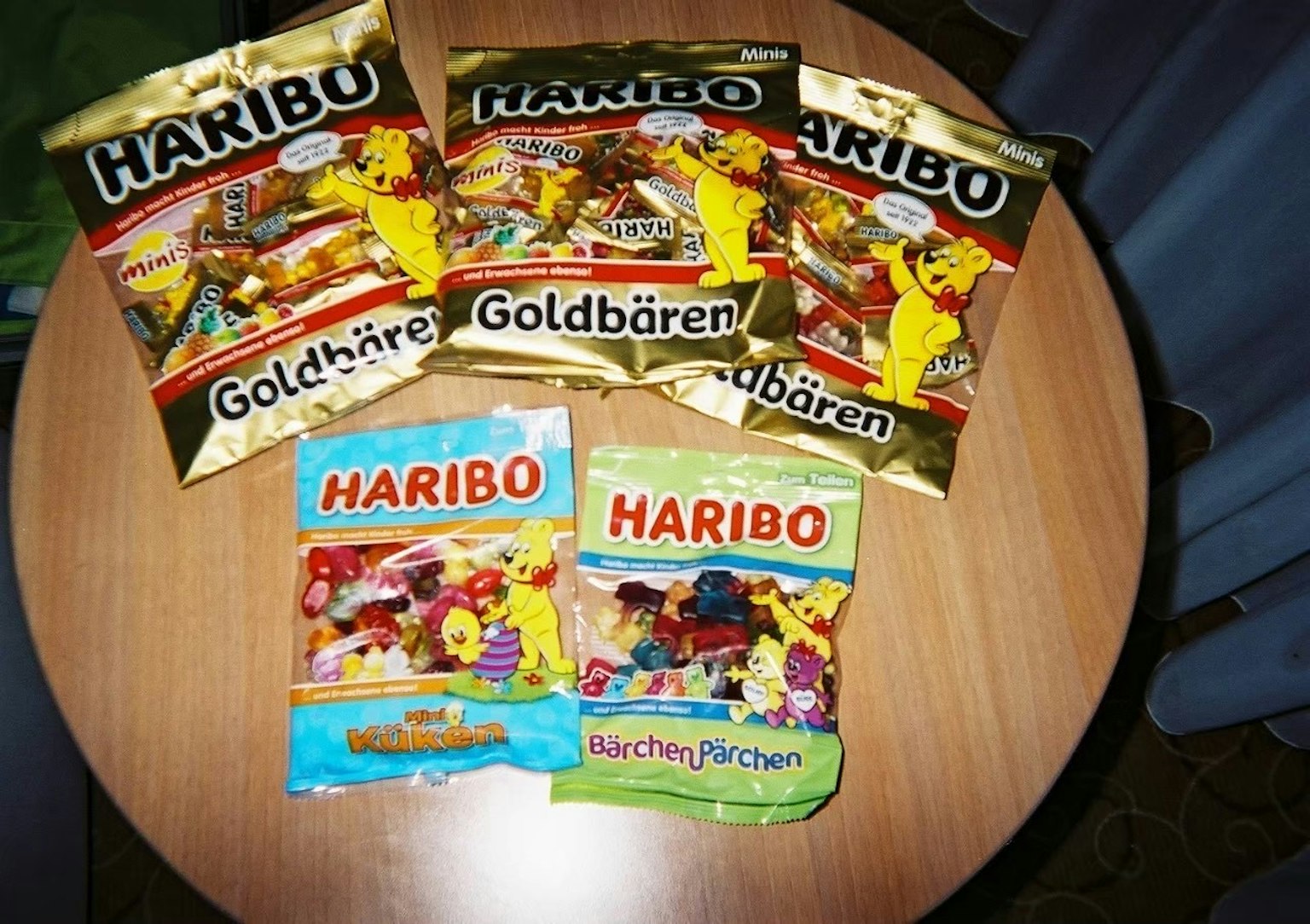 Vari pacchetti di caramelle Haribo tra cui Goldbären e Mix-Peaches su un tavolo di legno
