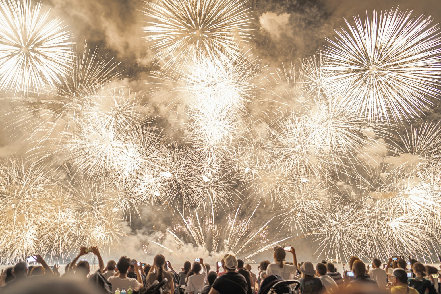 Spettacolare spettacolo di fuochi d'artificio bianchi con spettatori in ammirazione