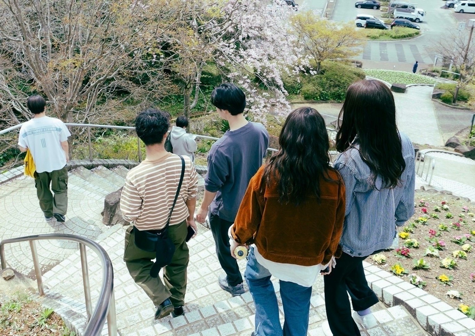 Grupo de jóvenes bajando escaleras en un parque de primavera