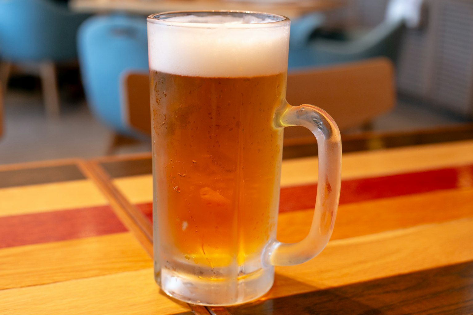 Jarra de cerveza clara llena de cerveza dorada y espuma