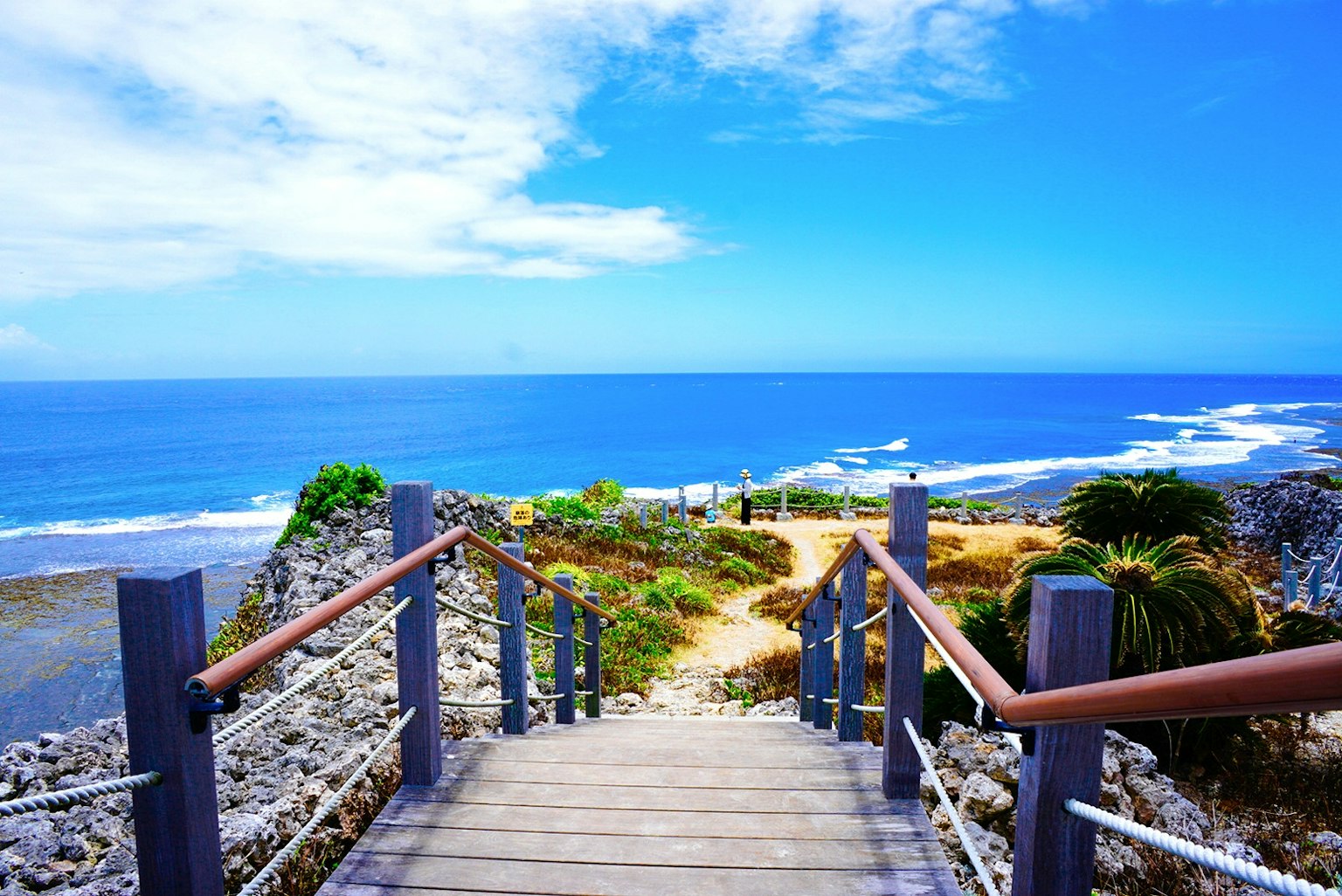 Escalier menant à une vue panoramique sur l'océan et le ciel bleus