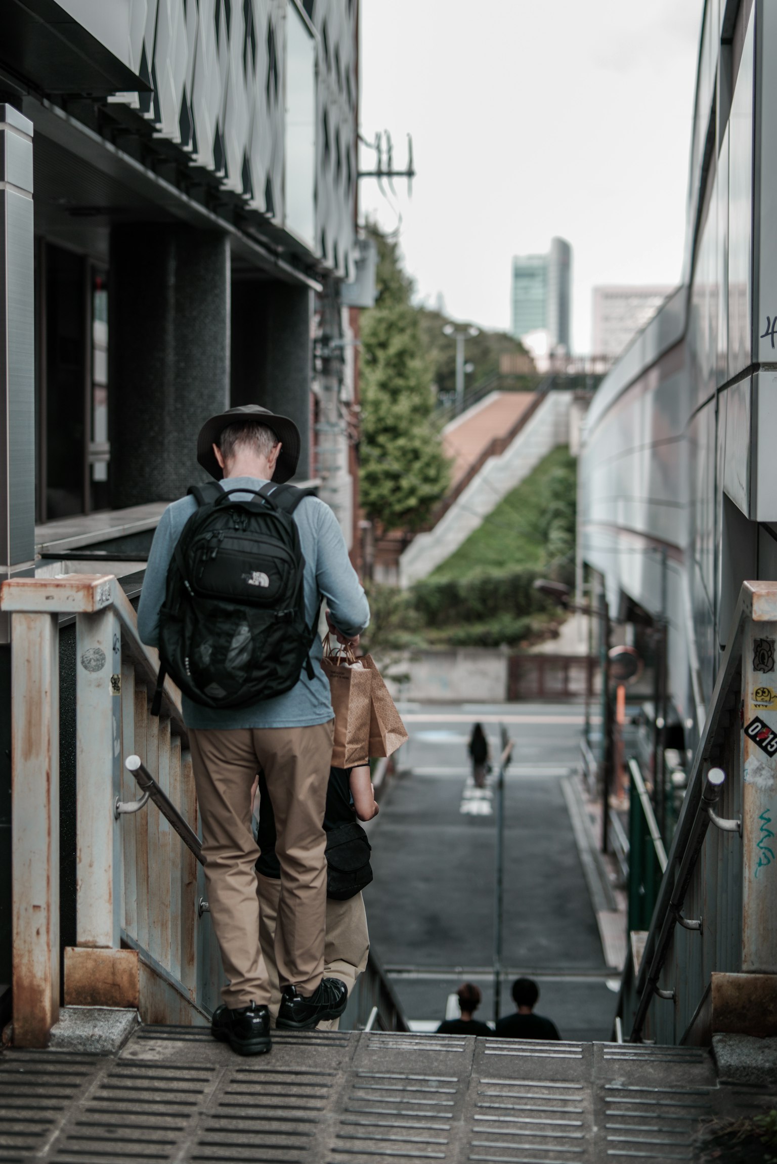 Hombre bajando escaleras con un paisaje urbano de fondo