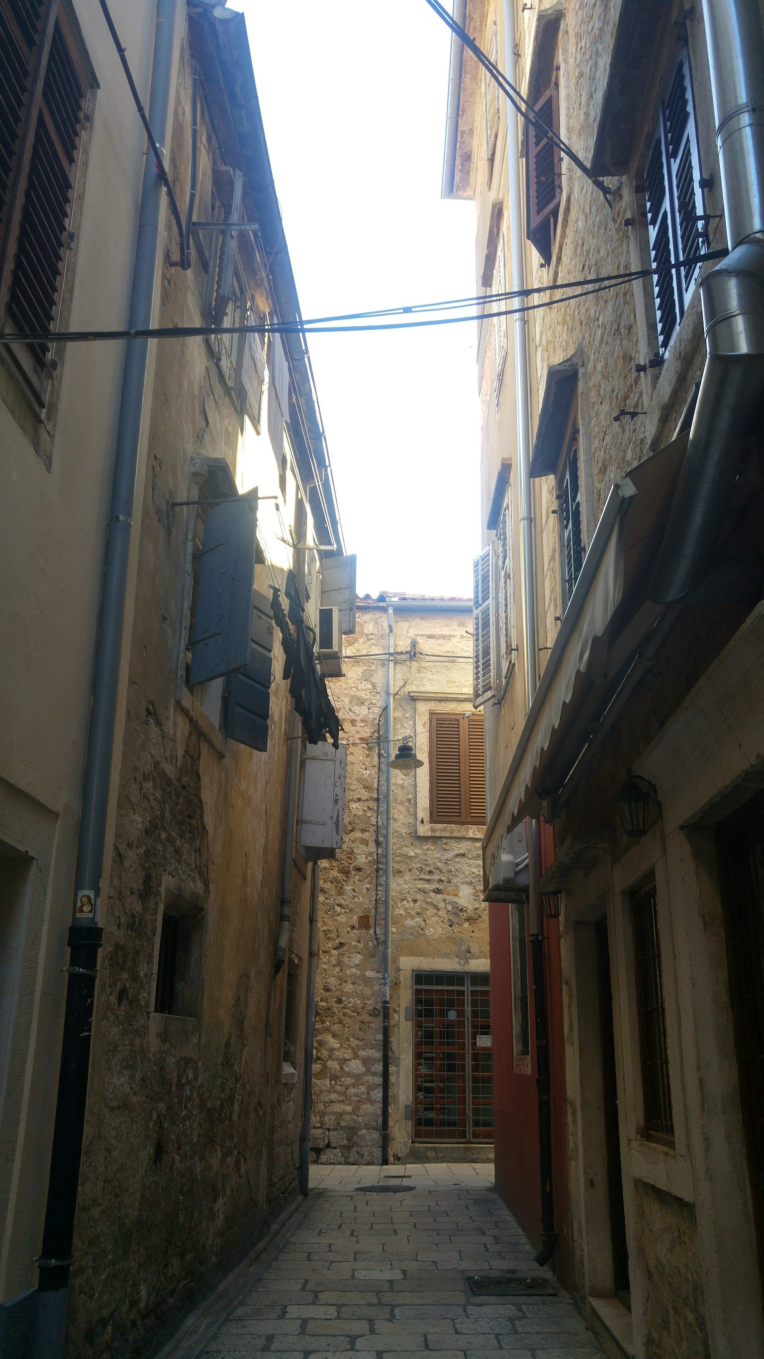 Vicolo stretto in pietra con edifici ai lati