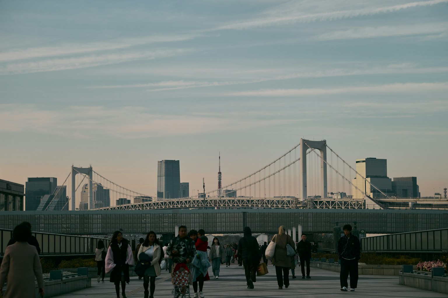 Menschenmenge mit der Rainbow Bridge und der Skyline von Tokio bei Dämmerung