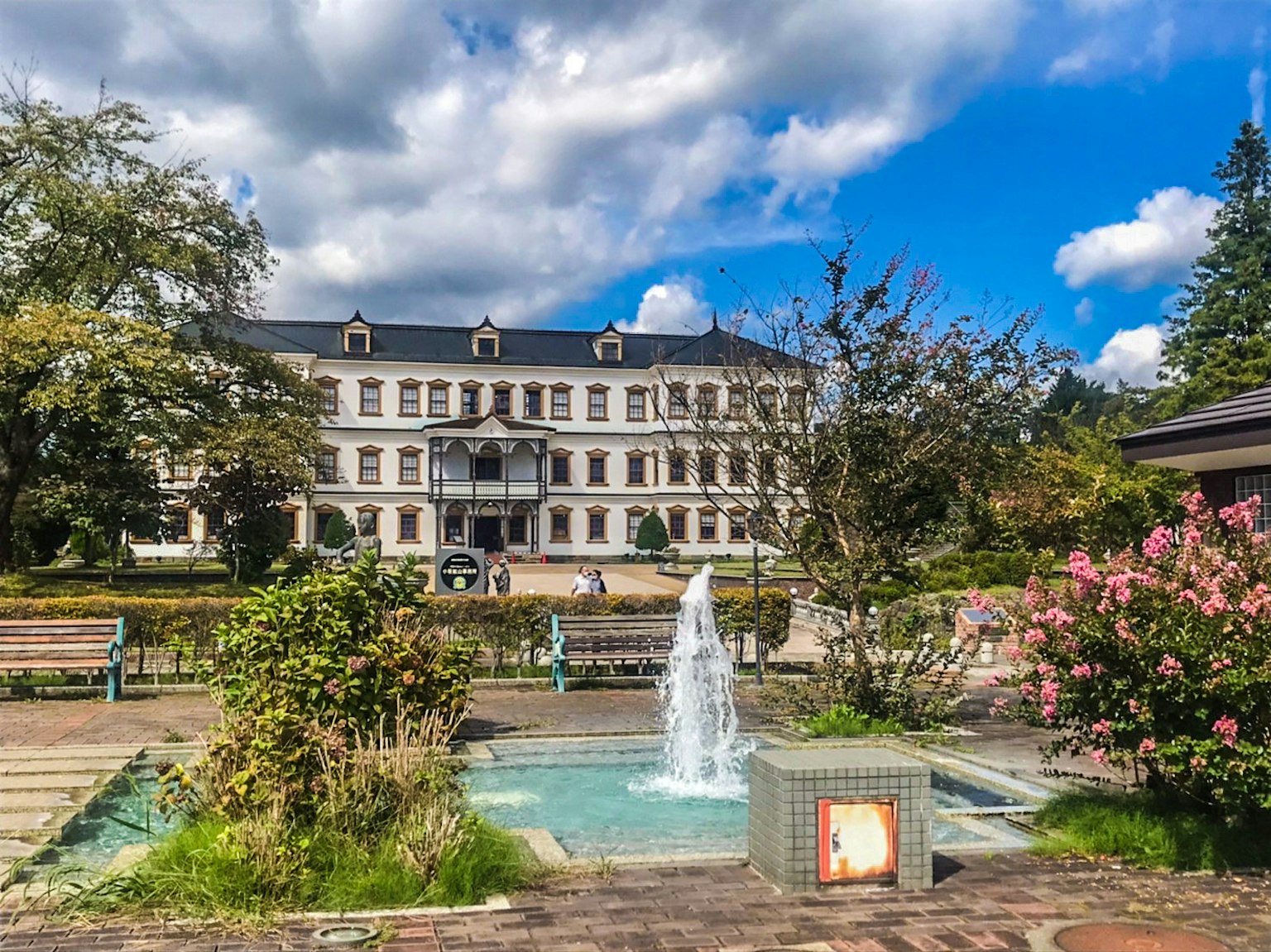 Edificio histórico con fuente y flores en un parque