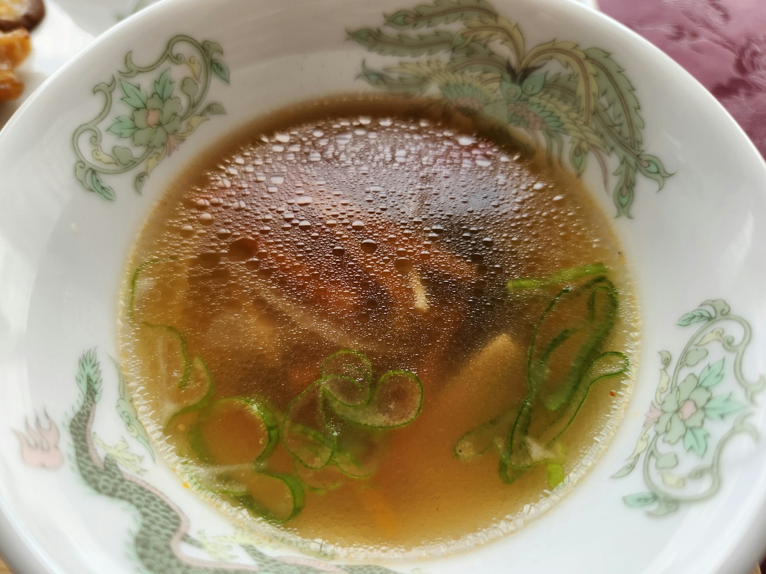 Bol de soupe chaude avec des oignons verts flottants