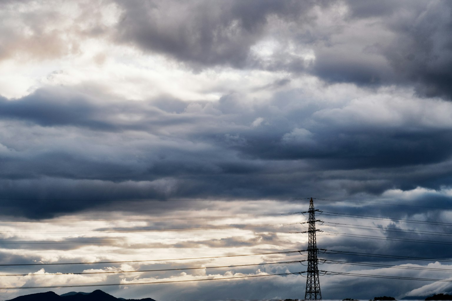 Dark clouds covering the sky with a silhouette of a communication tower