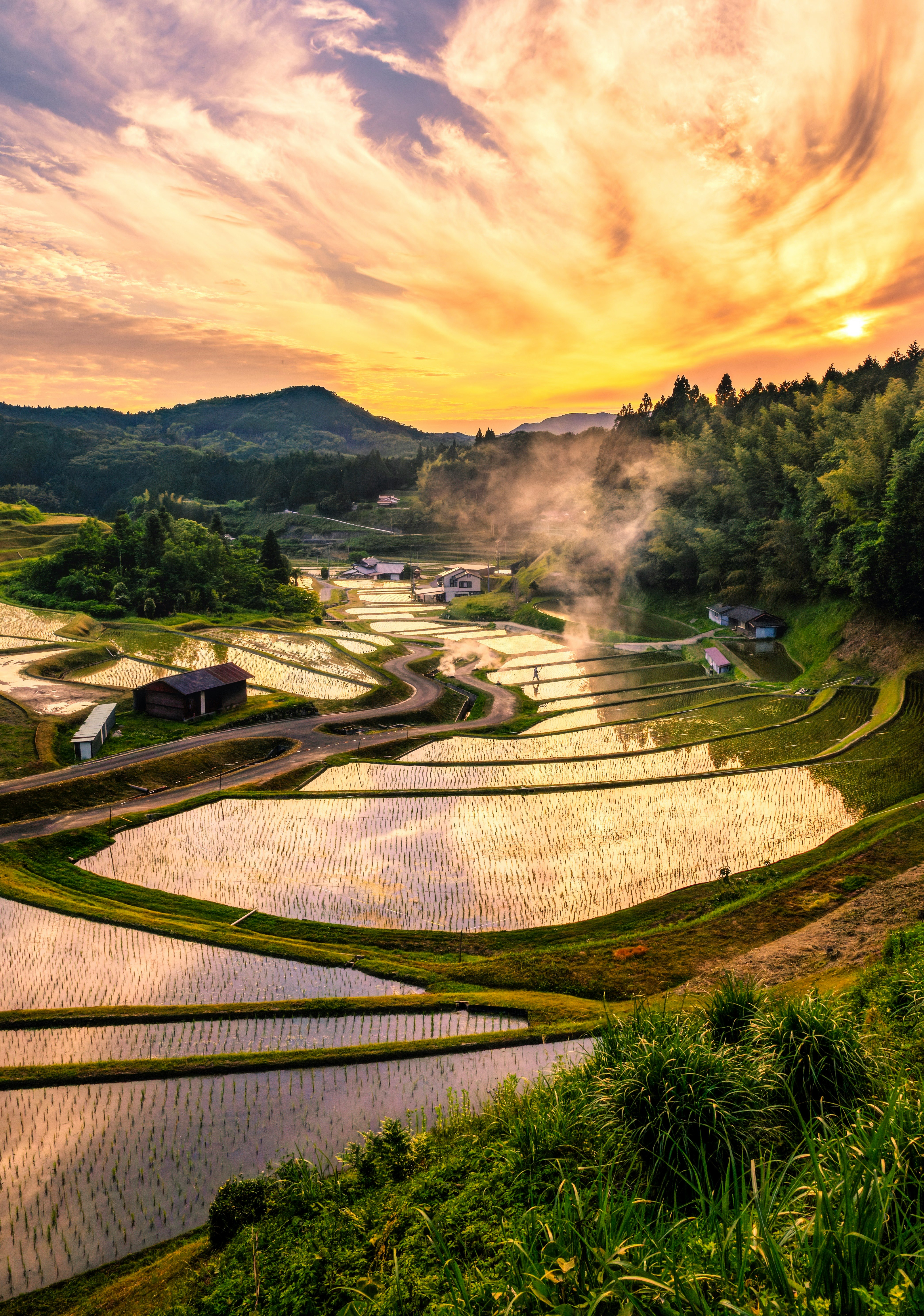 山口県周南市の棚田と夕焼けの空、湯気の立つ風景