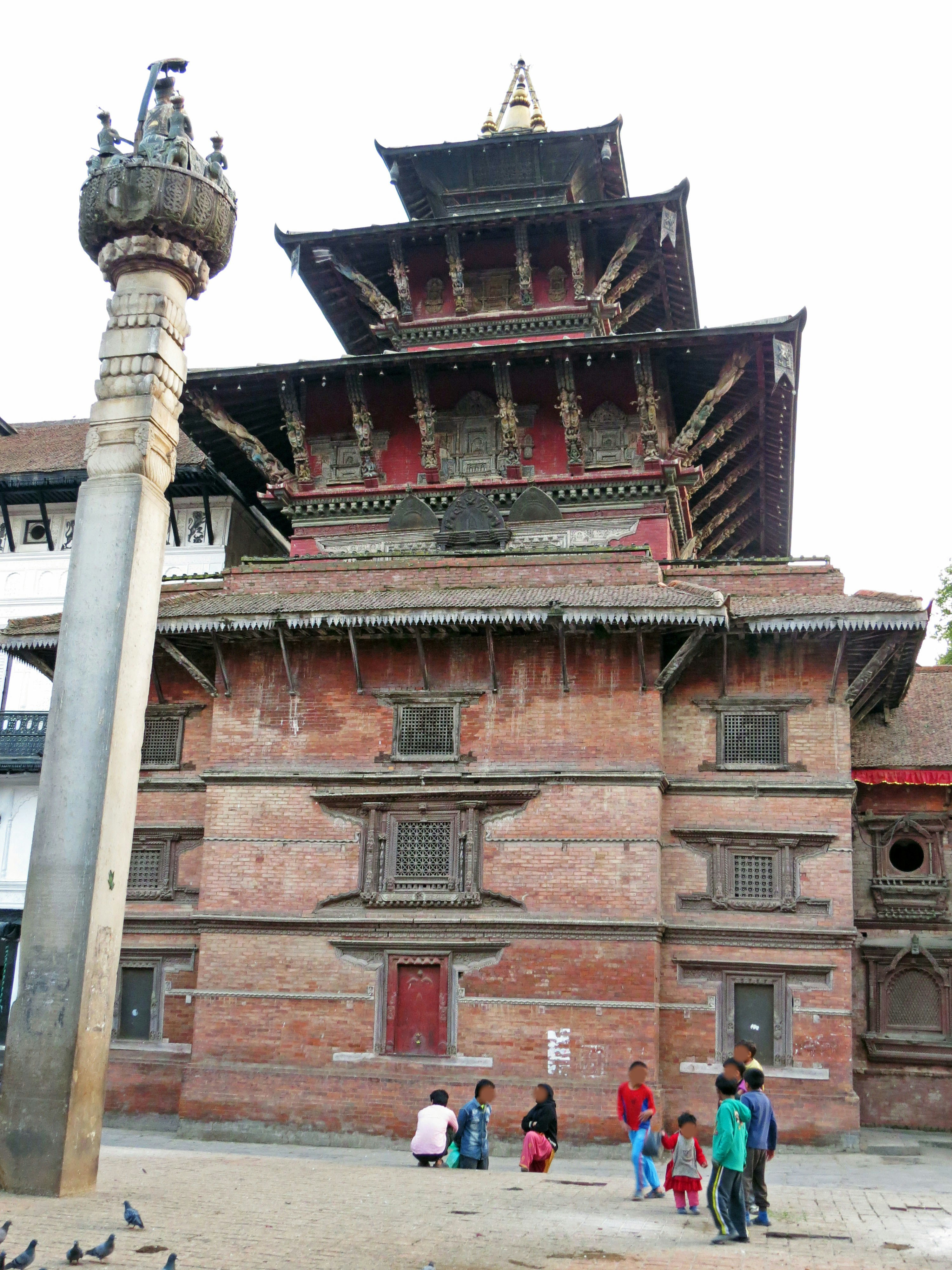 红砖寺庙建筑与石塔相映的庭院