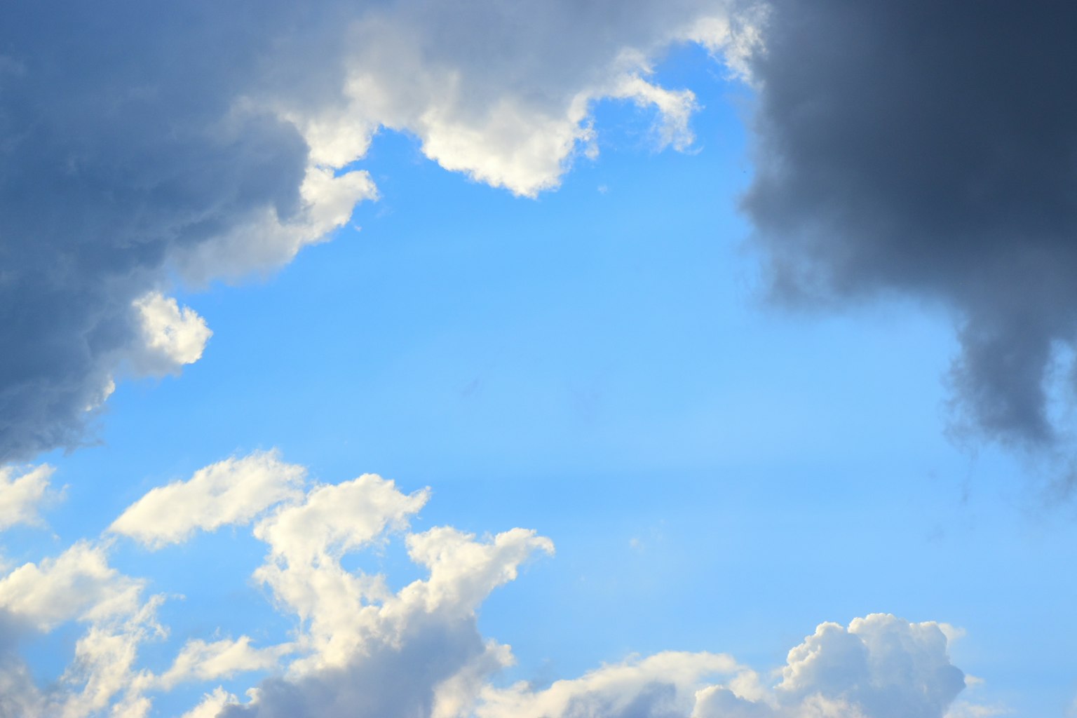 Klarer blauer Himmel mit flauschigen weißen Wolken