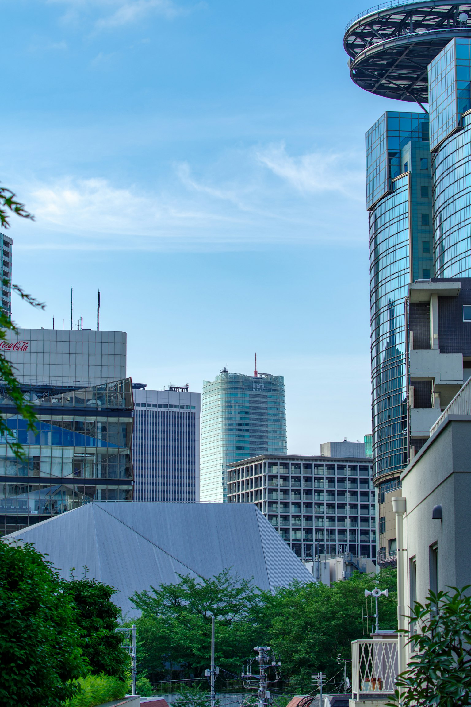 Stadtlandschaft mit Wolkenkratzern und blauem Himmel sowie Grünflächen