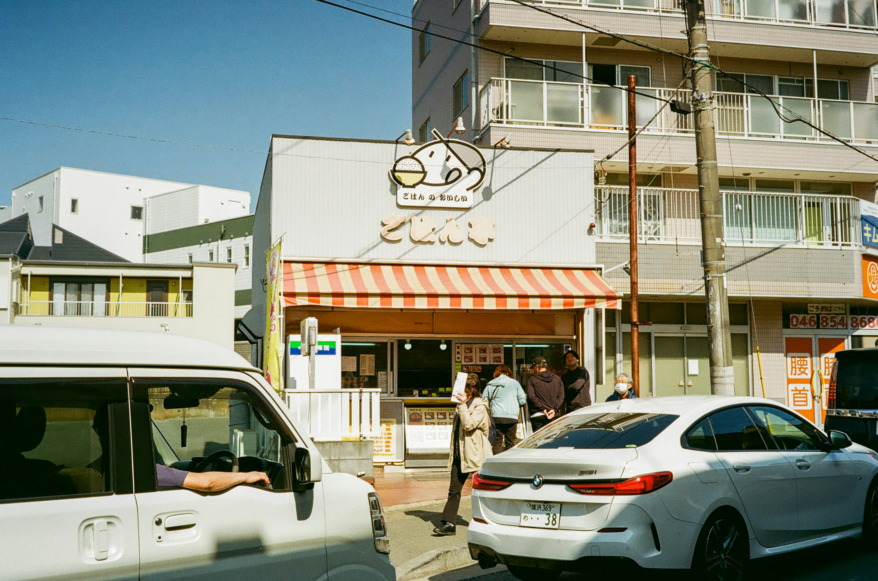 看板のある商店街の路地と駐車車両のある街角