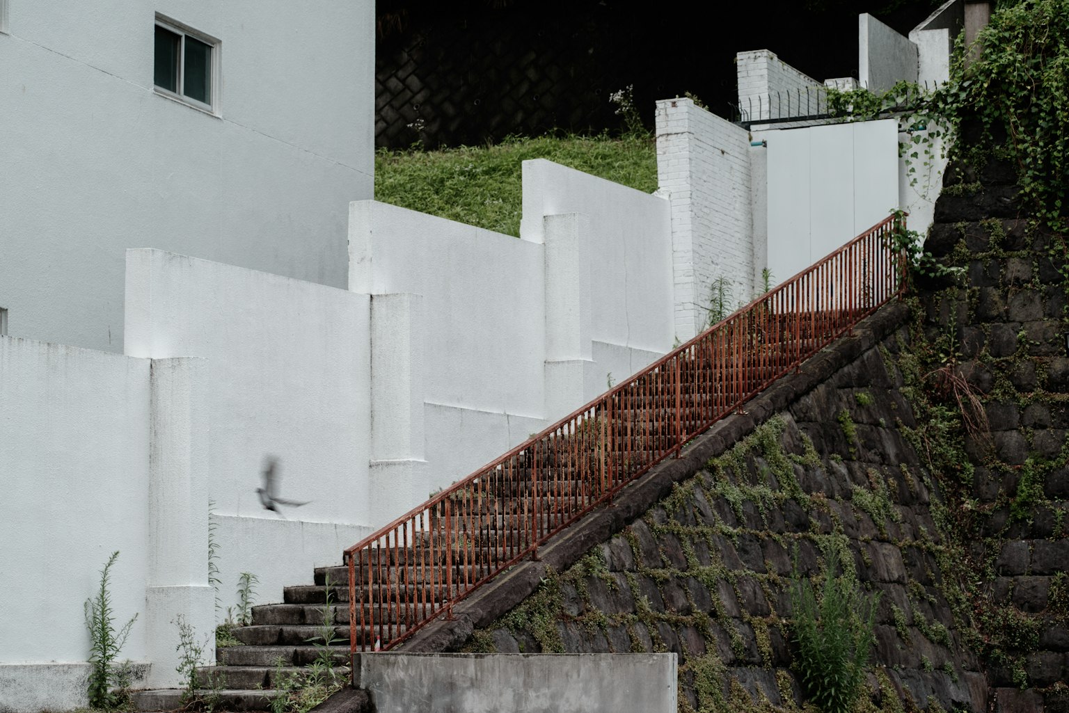 Landscape featuring white walls and a staircase with a red railing