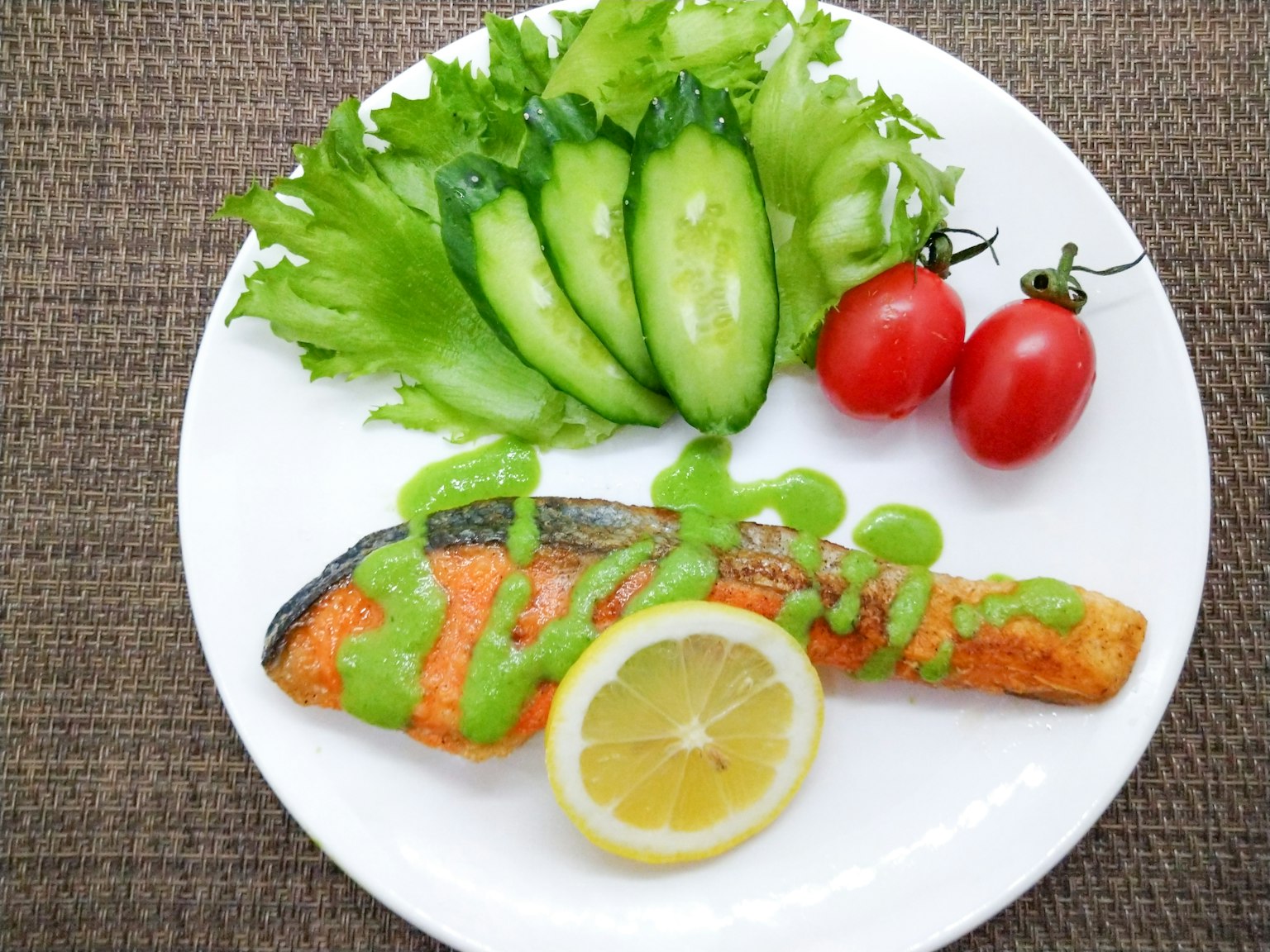 Assiette de filet de saumon grillé avec tranche de citron concombre et tomates cerises
