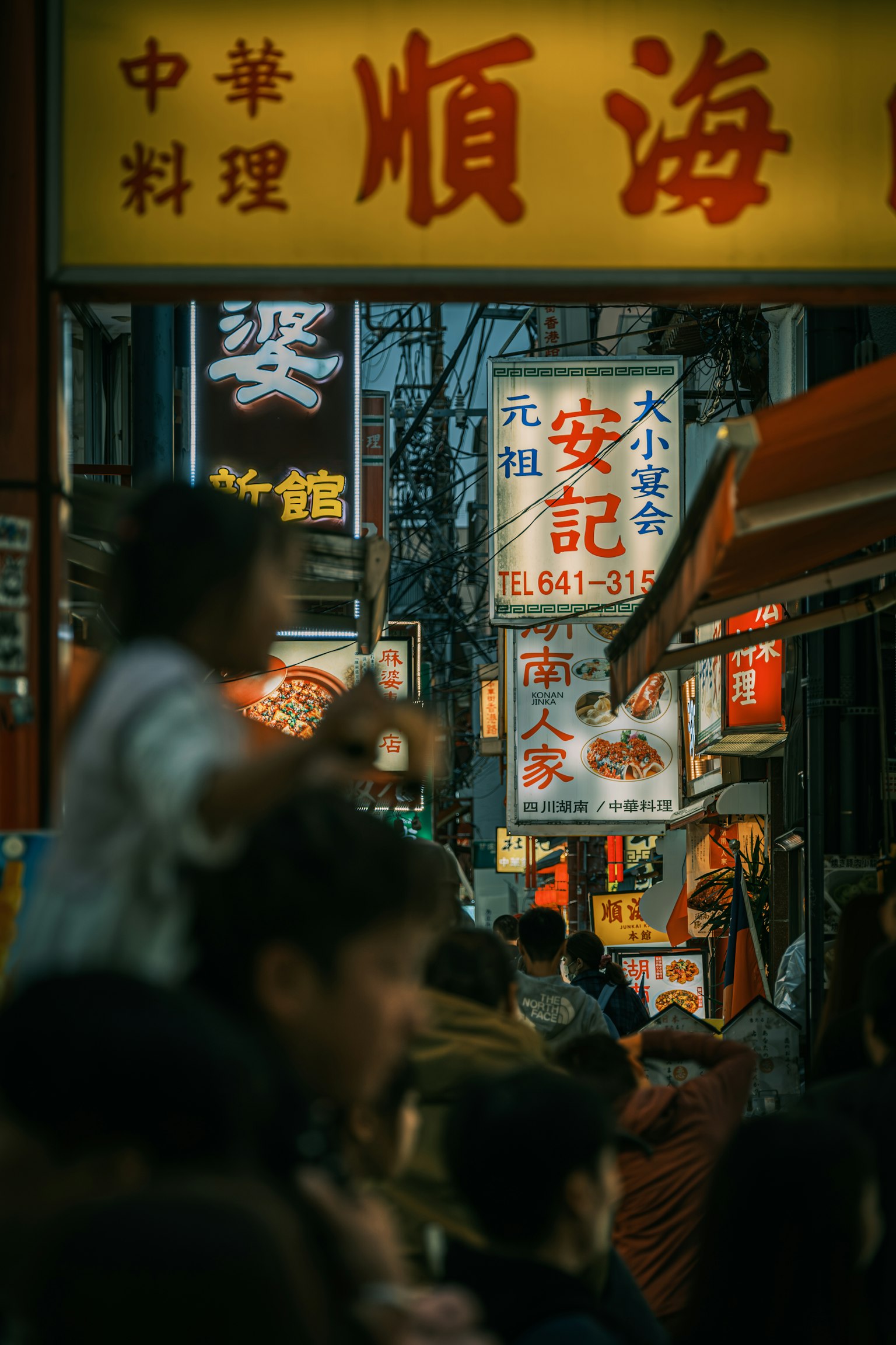 賑やかな街並みの中華料理店の看板と人々の群れ