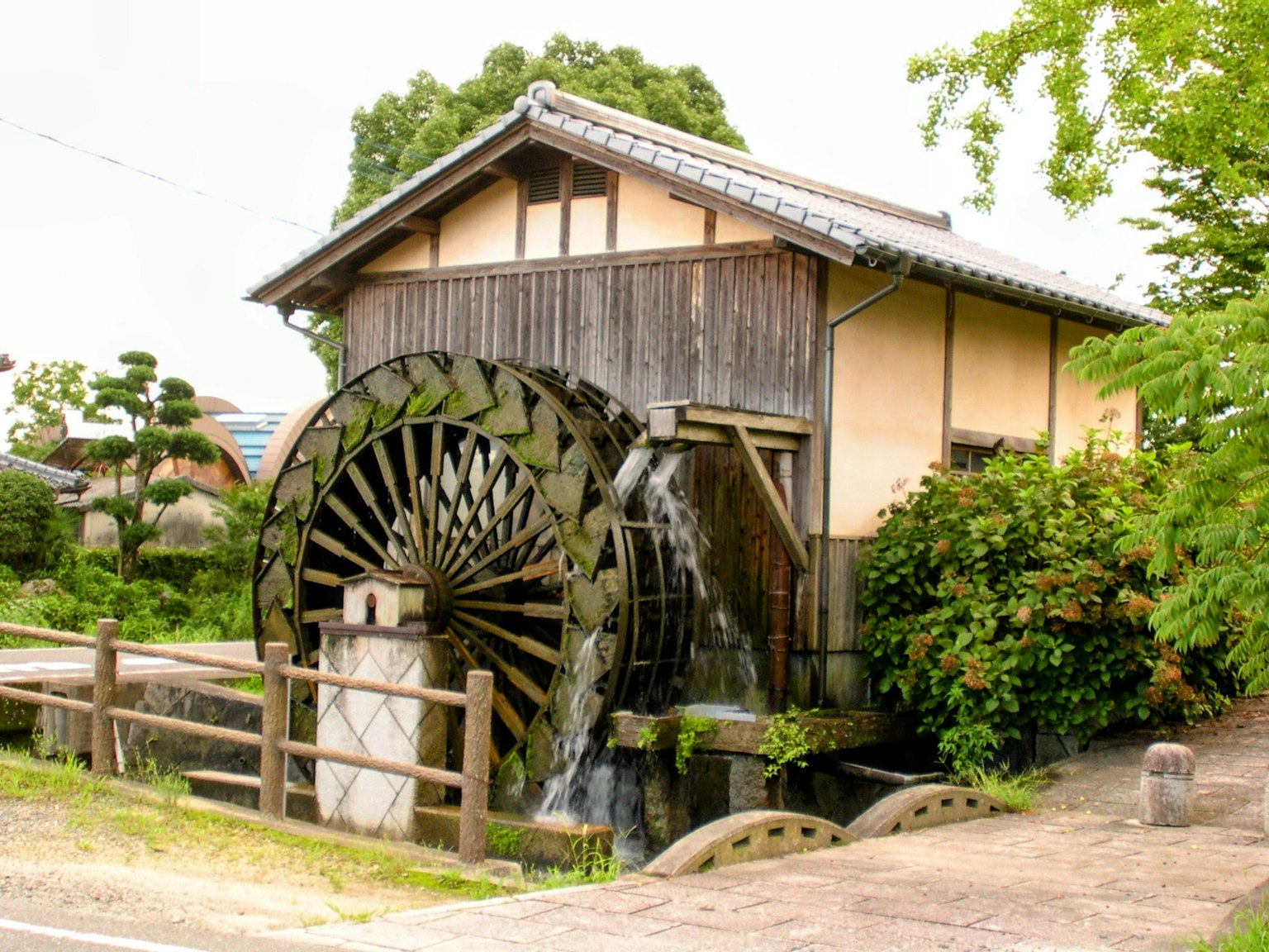 Water wheel beside a wooden house in a rural setting